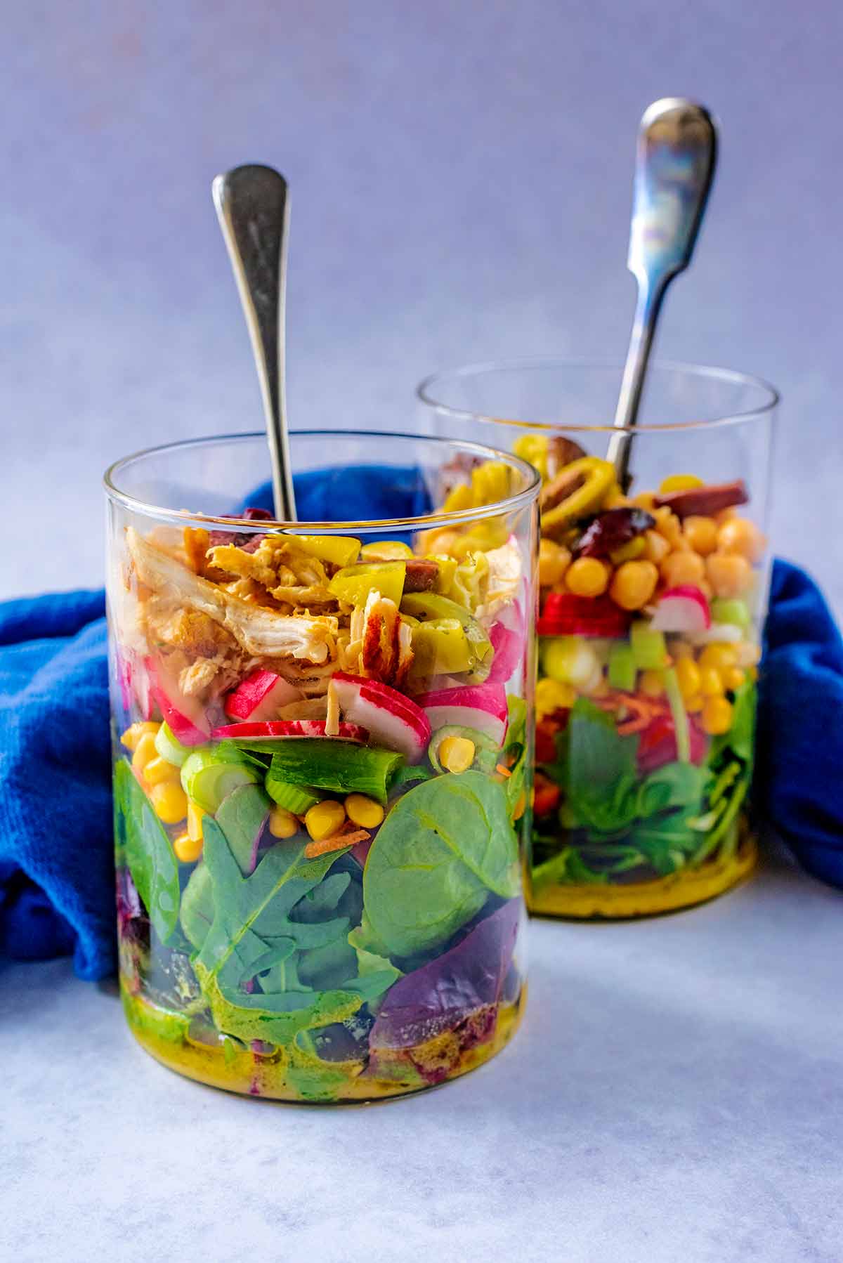 Two large jars layered with salad items.