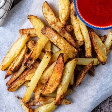 A pile of air fryer chips on a sheet of baking paper.