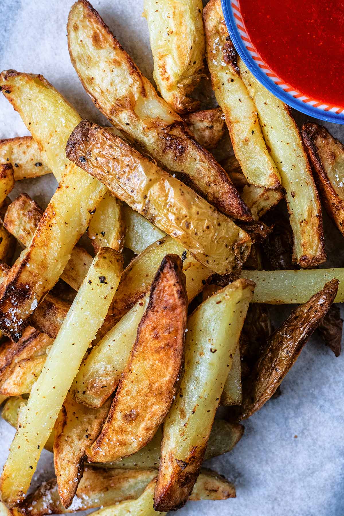 Seasoned chips next to some tomato ketchup.