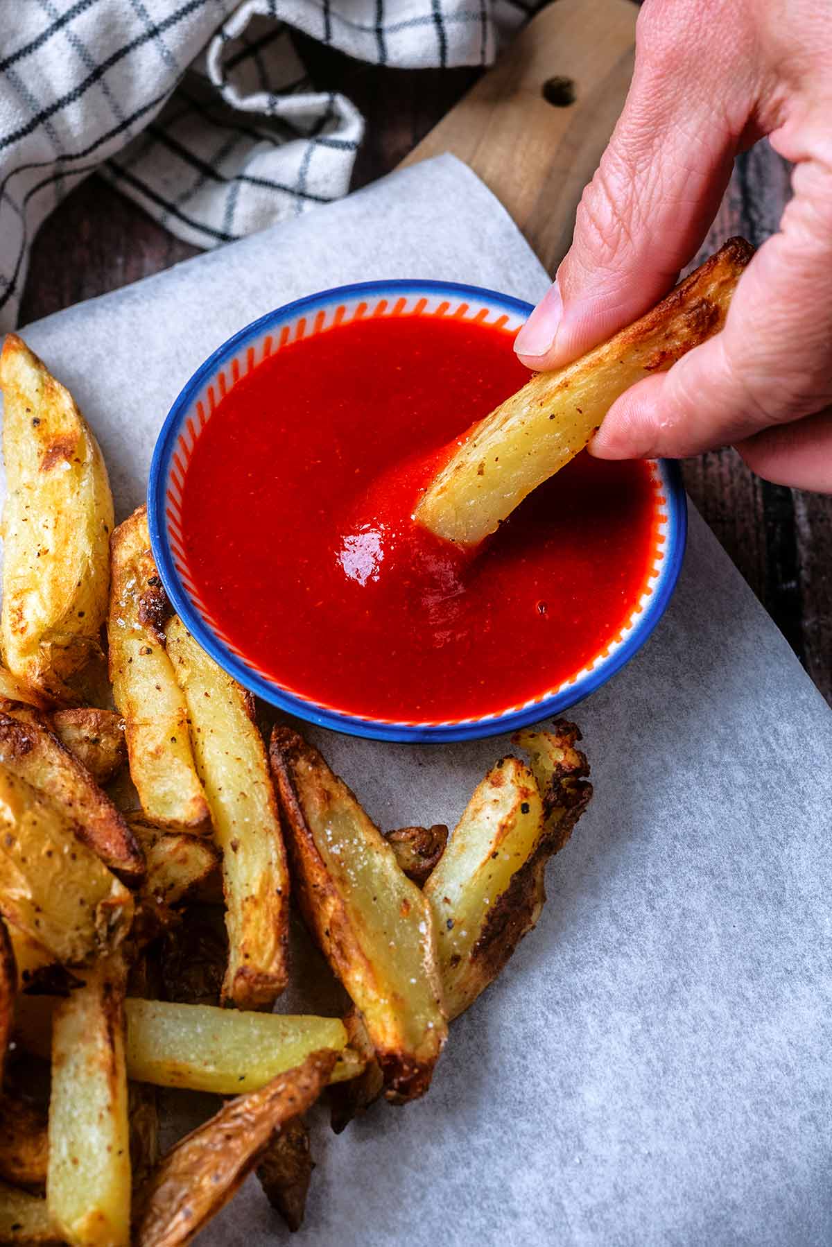 A chip being dipped into some ketchup.