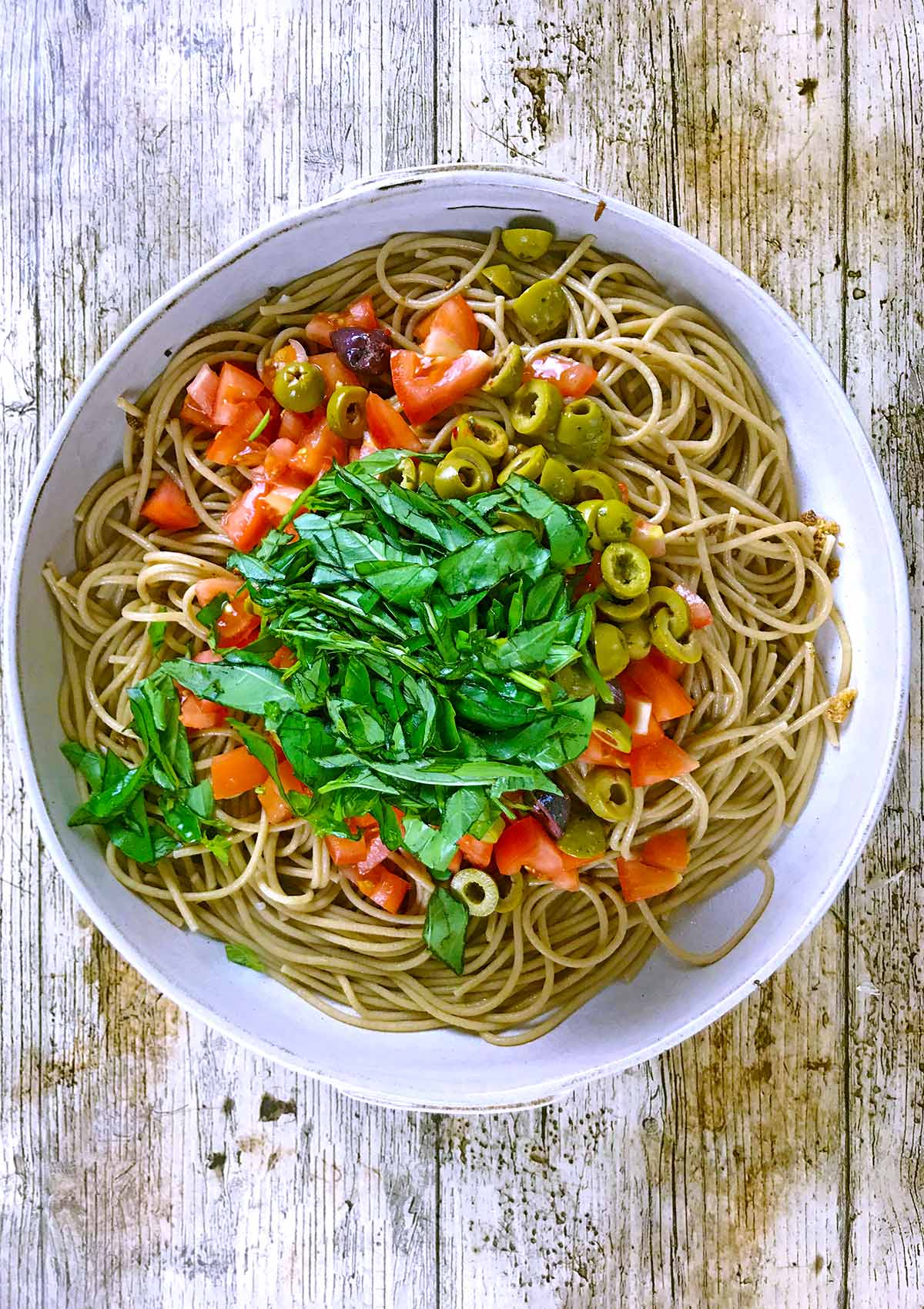Chopped tomatoes, sliced olives and strips of basil leaves added to the spaghetti.