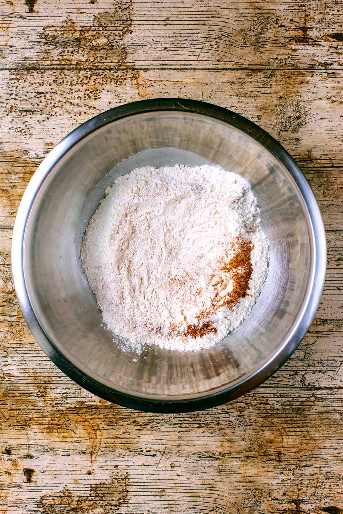 A mixing bowl containing flour and cinnamon.