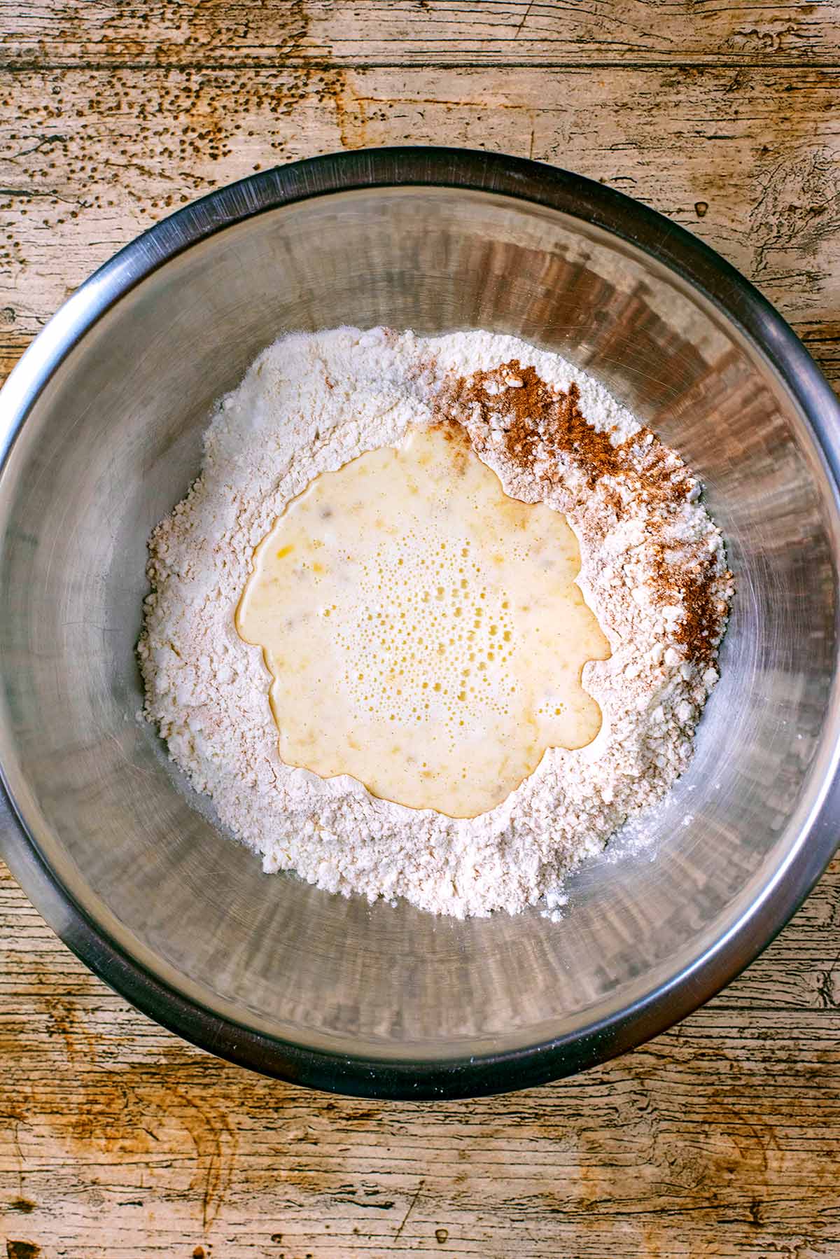 A mixing bowl containing unmixed pancake ingredients.