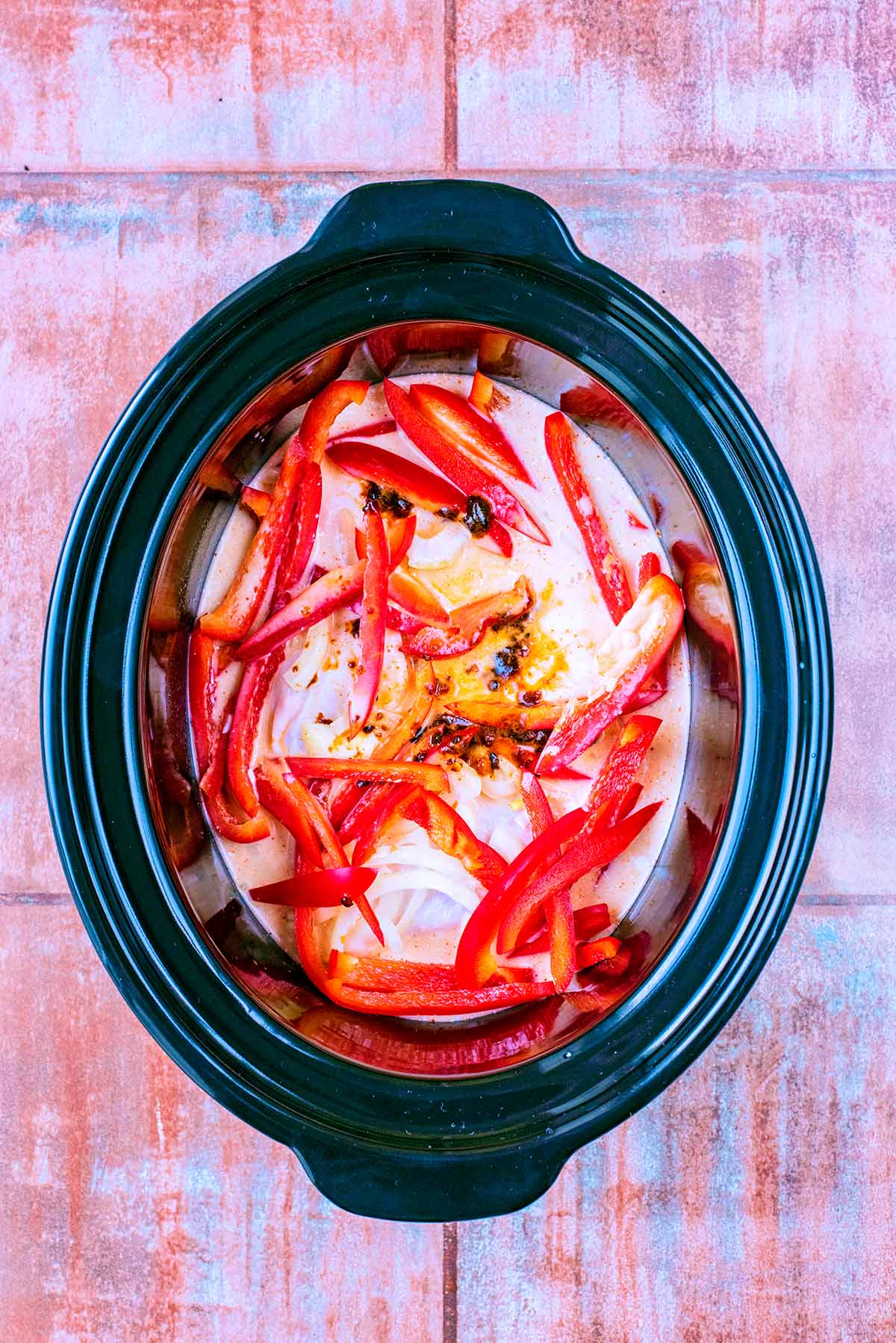 Coconut milk and curry paste added to the slow cooker.