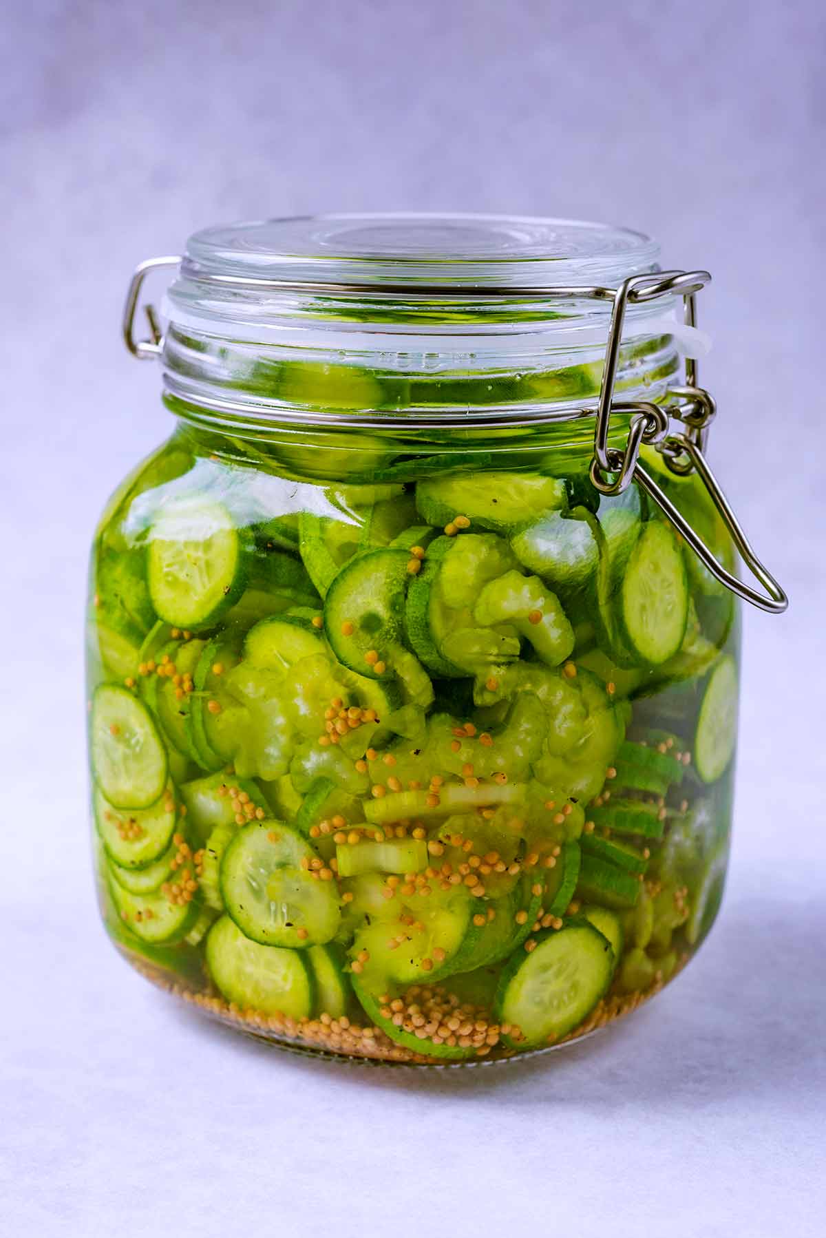 A glass jar full of pickled cucumbers.