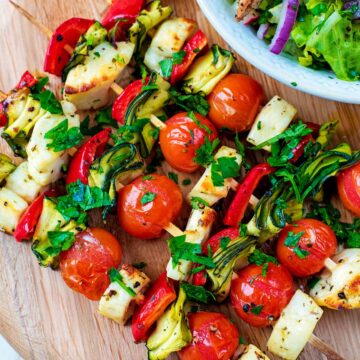 Vegetable and Halloumi Kebabs on a circular chopping board.