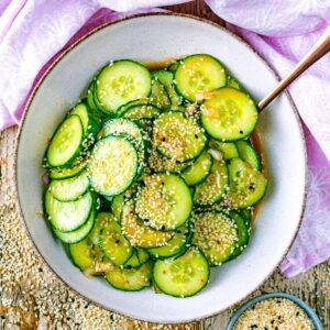 Asian cucumber salad in a bowl with a spoon.