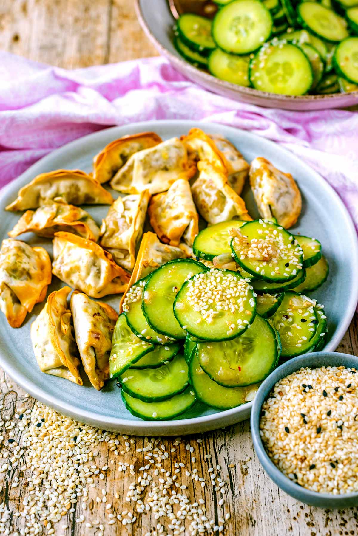 Cucumber salad on a plate with some gyoza.