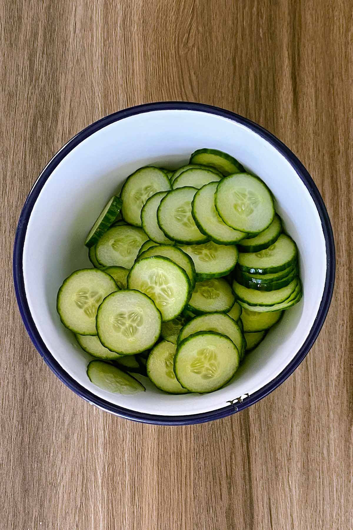 A bowl containing slices of cucumber.
