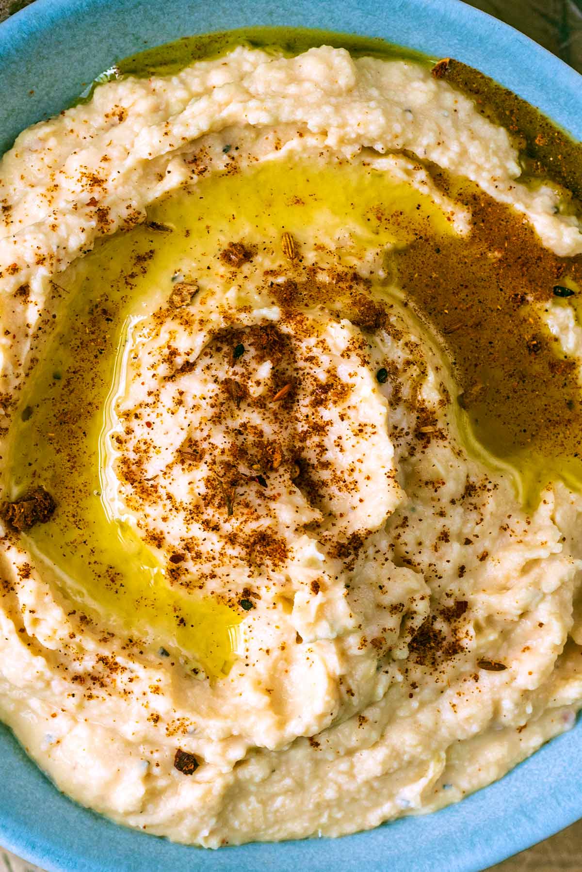 Hummus topped with oil and a sprinkling of ras el hanout.