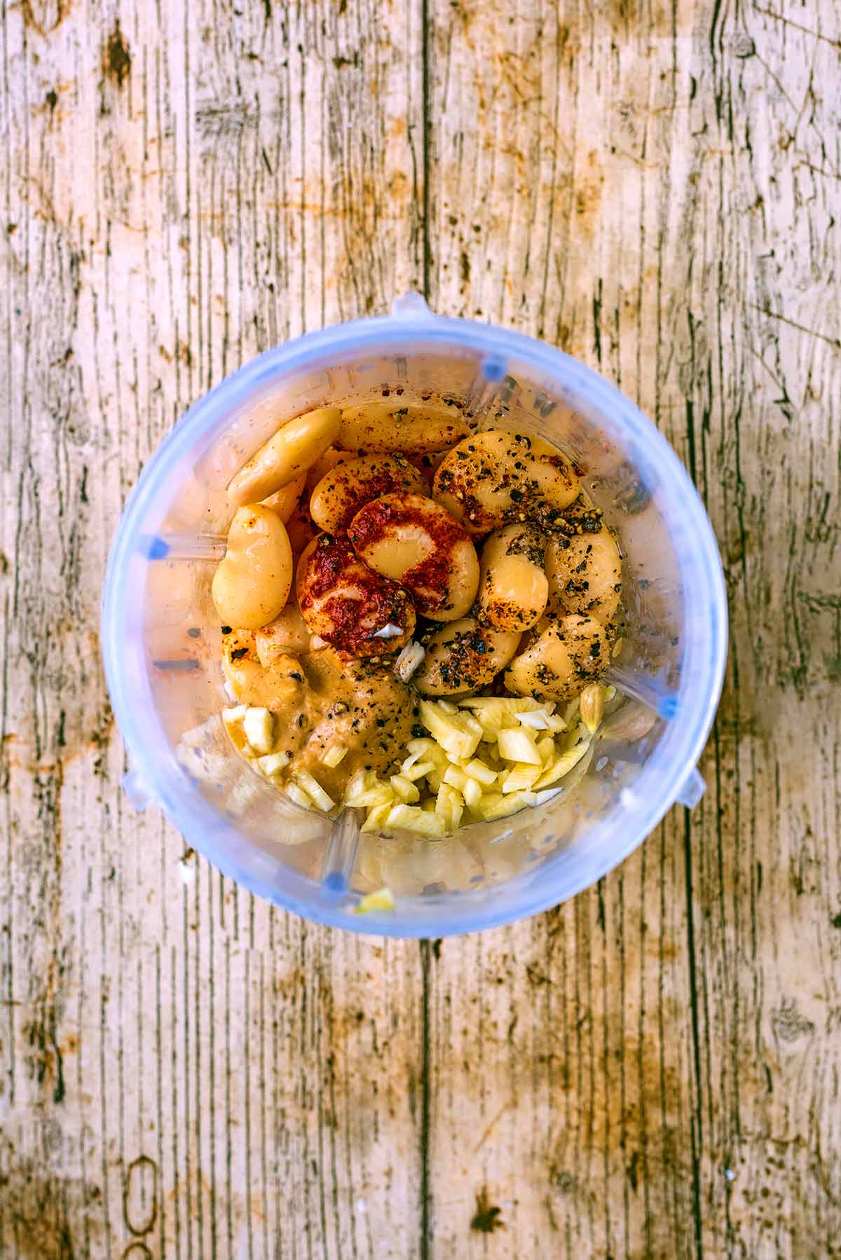 Hummus ingredients in a blender jug as viewed from above.