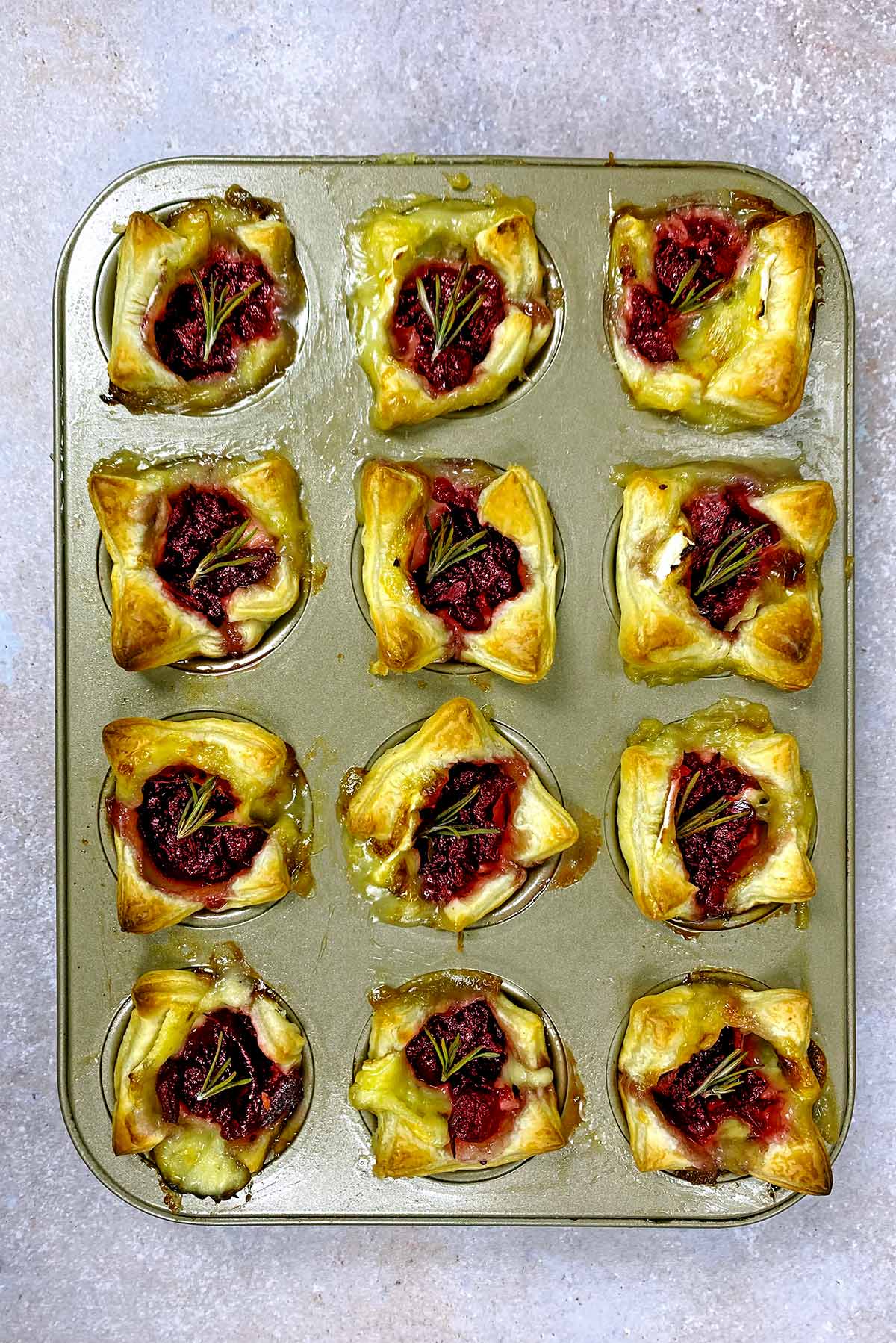Cooked cranberry bites in a muffin tin.