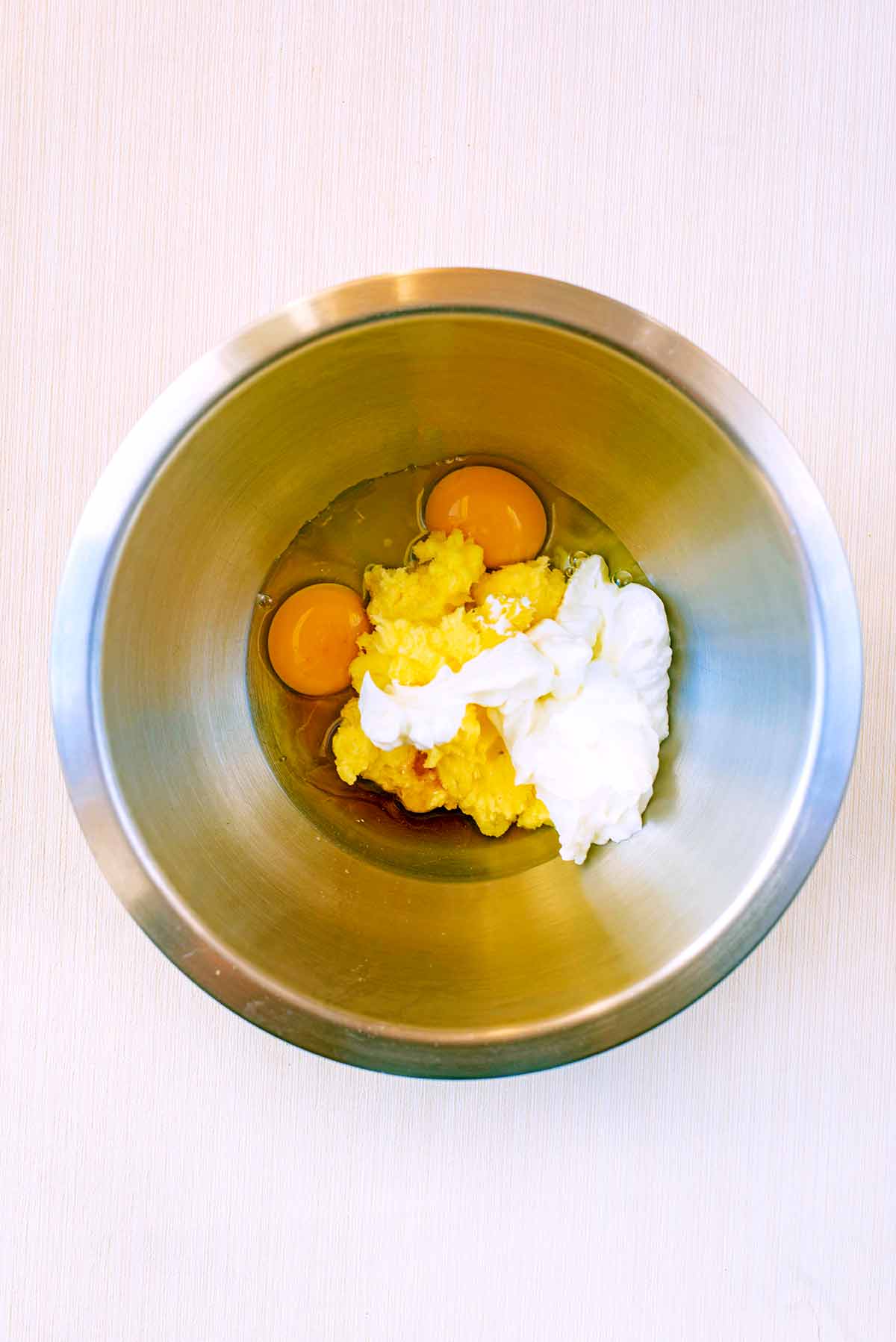 Eggs, vanilla and yogurt added to the bowl.