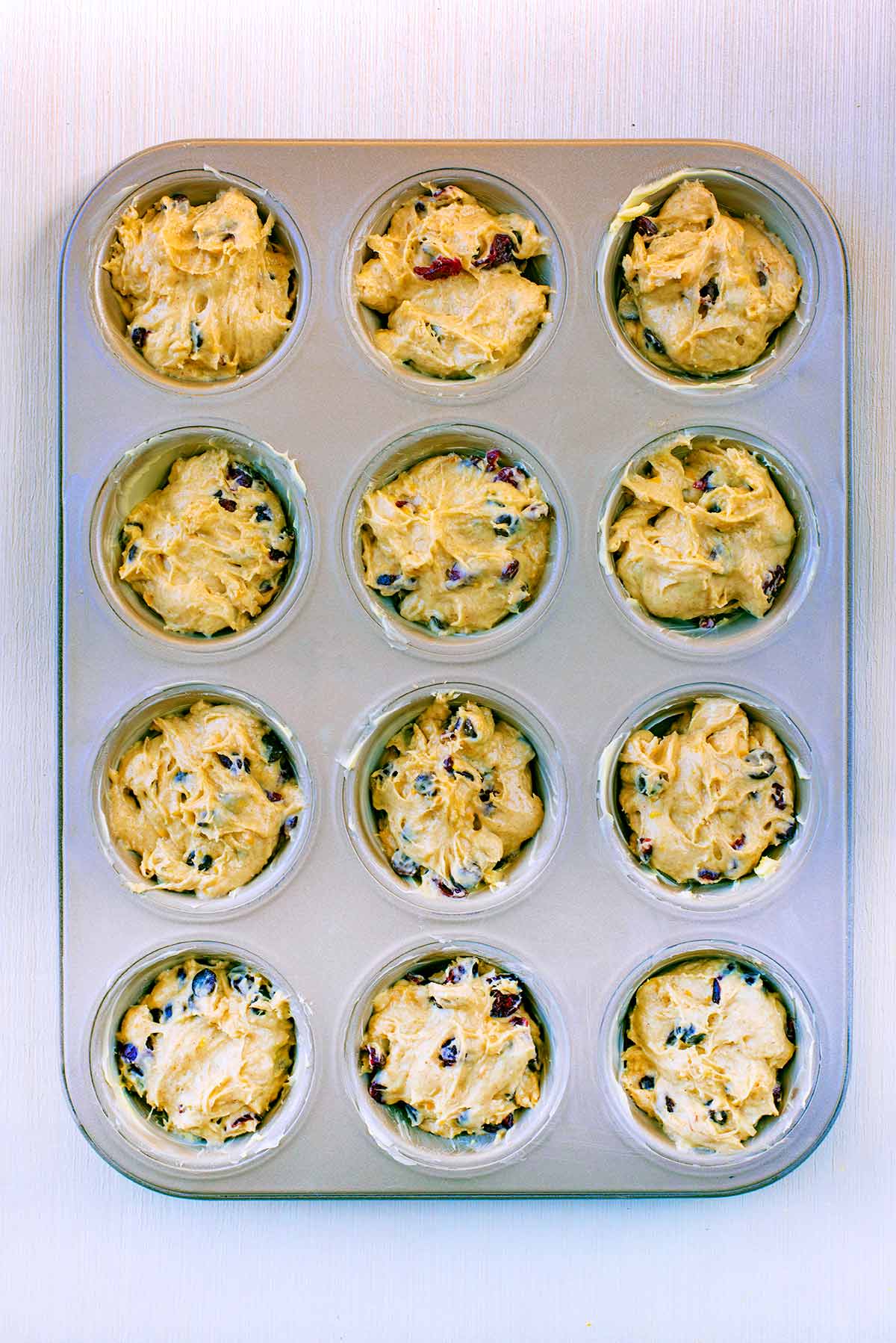 A twelve hole muffin tin filled with batter.