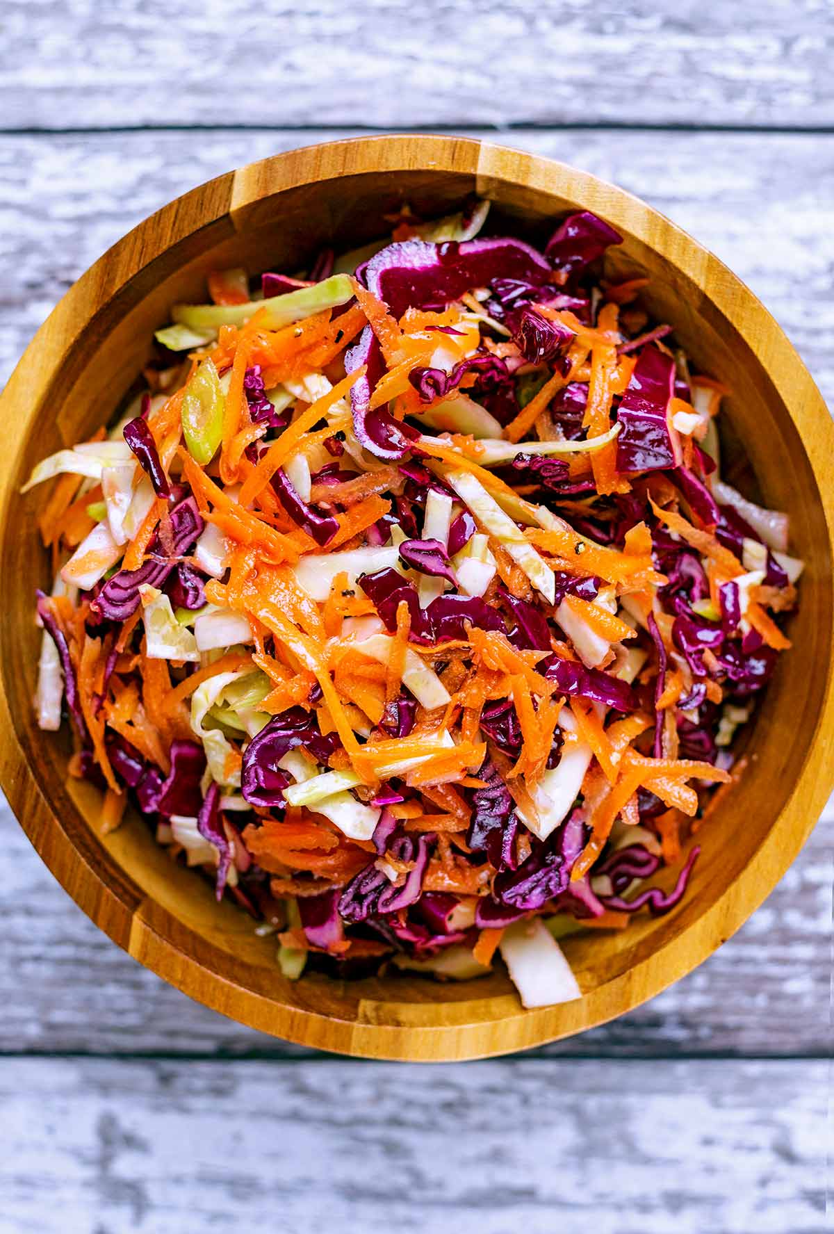 A wooden bowl containing slaw.