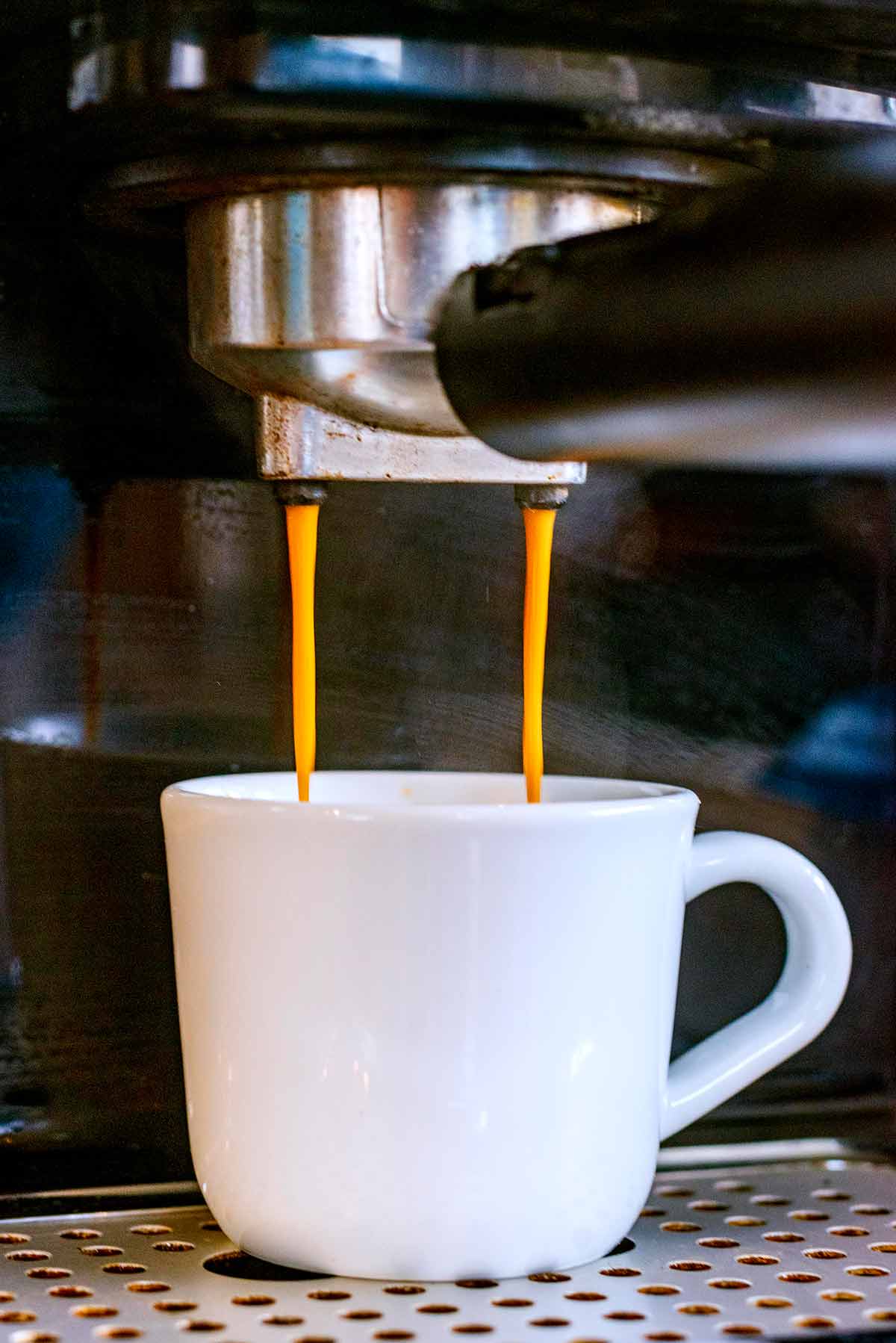 Coffee being brewed into an espresso cup.