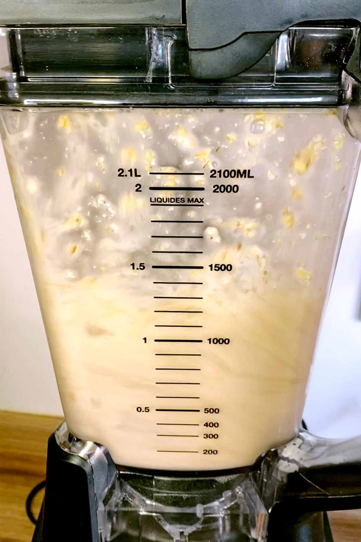 Oat milk being blended in a jug blender.