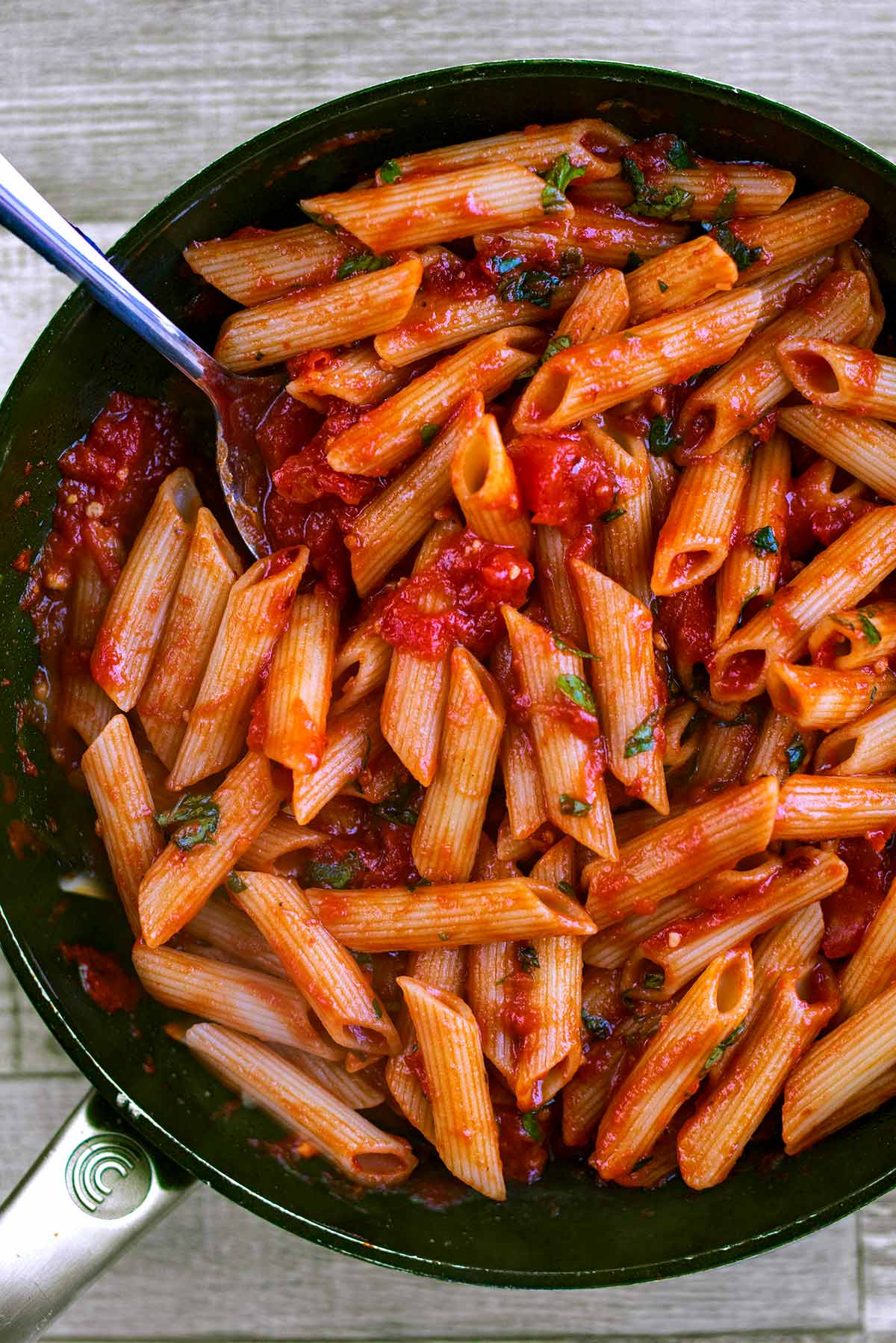 Cooked penne pasta mixed with arrabbiata sauce.