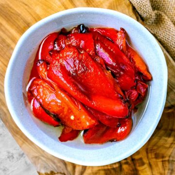Roasted red peppers in a small blue bowl.