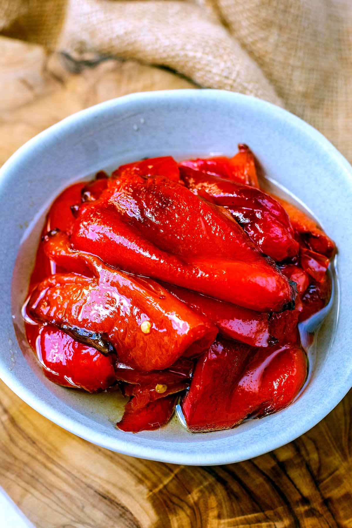 A bowl of roasted red peppers in oil.