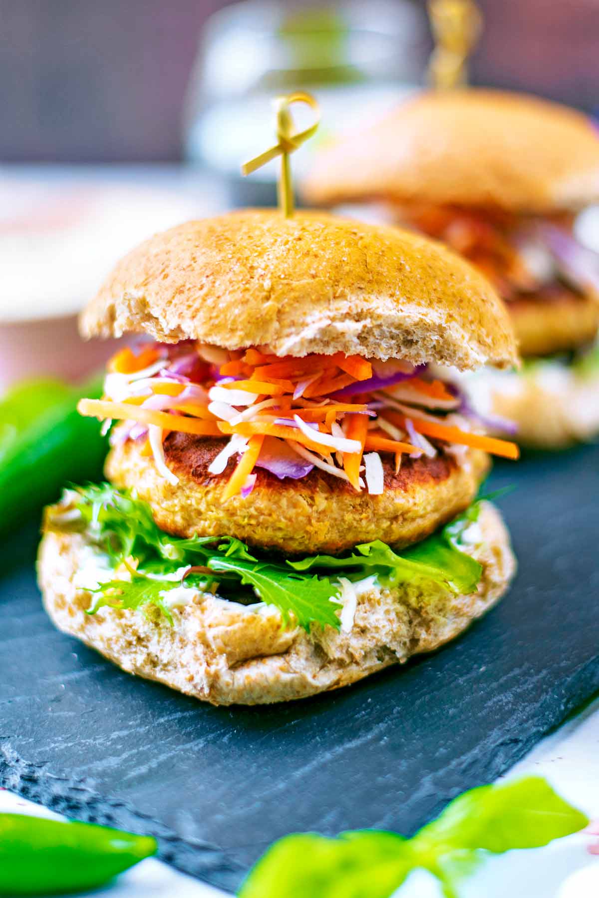 Salmon burger in a bun with lettuce and slaw.