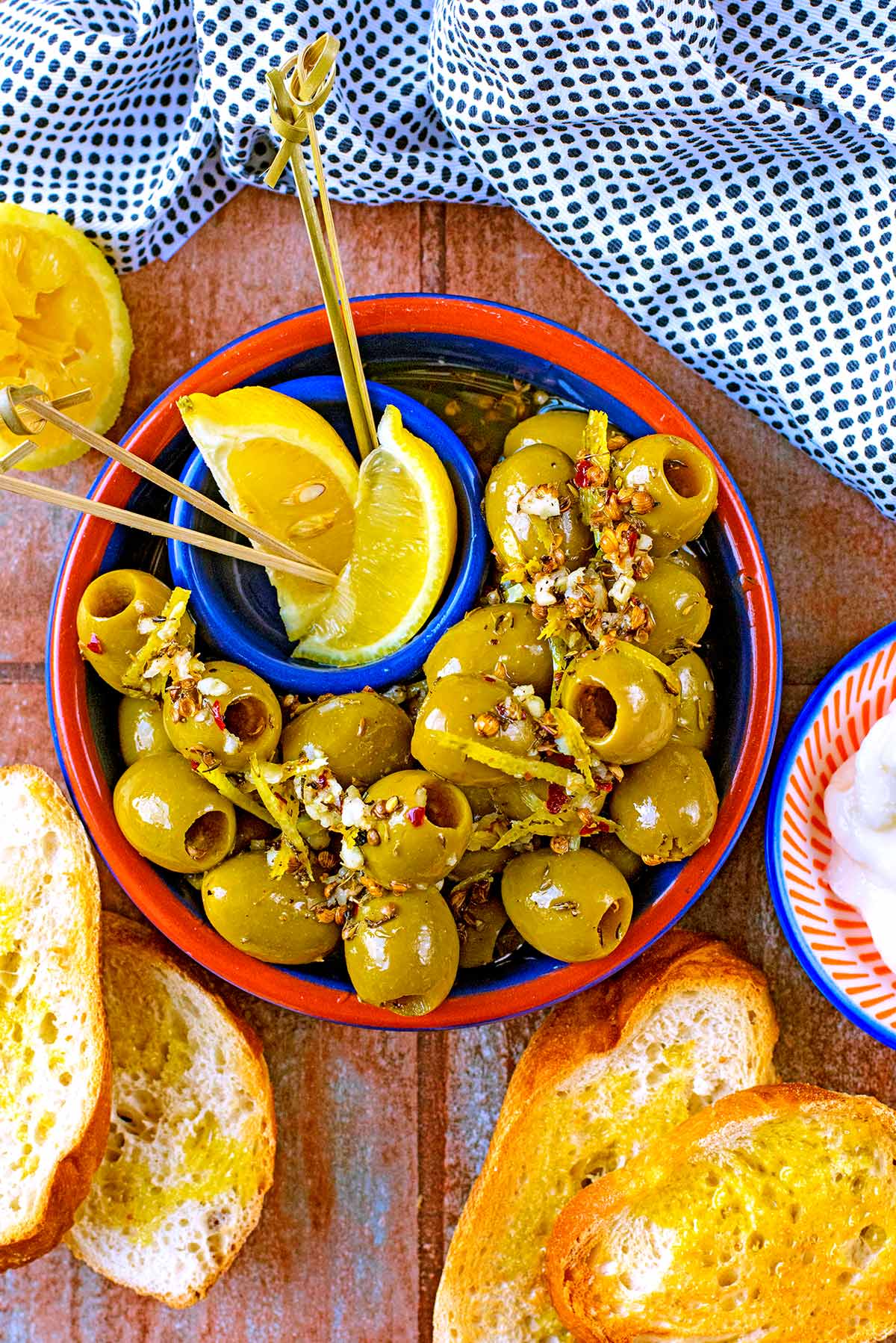 Spanish Olives in a bowl with two lemon wedges and olive picks.