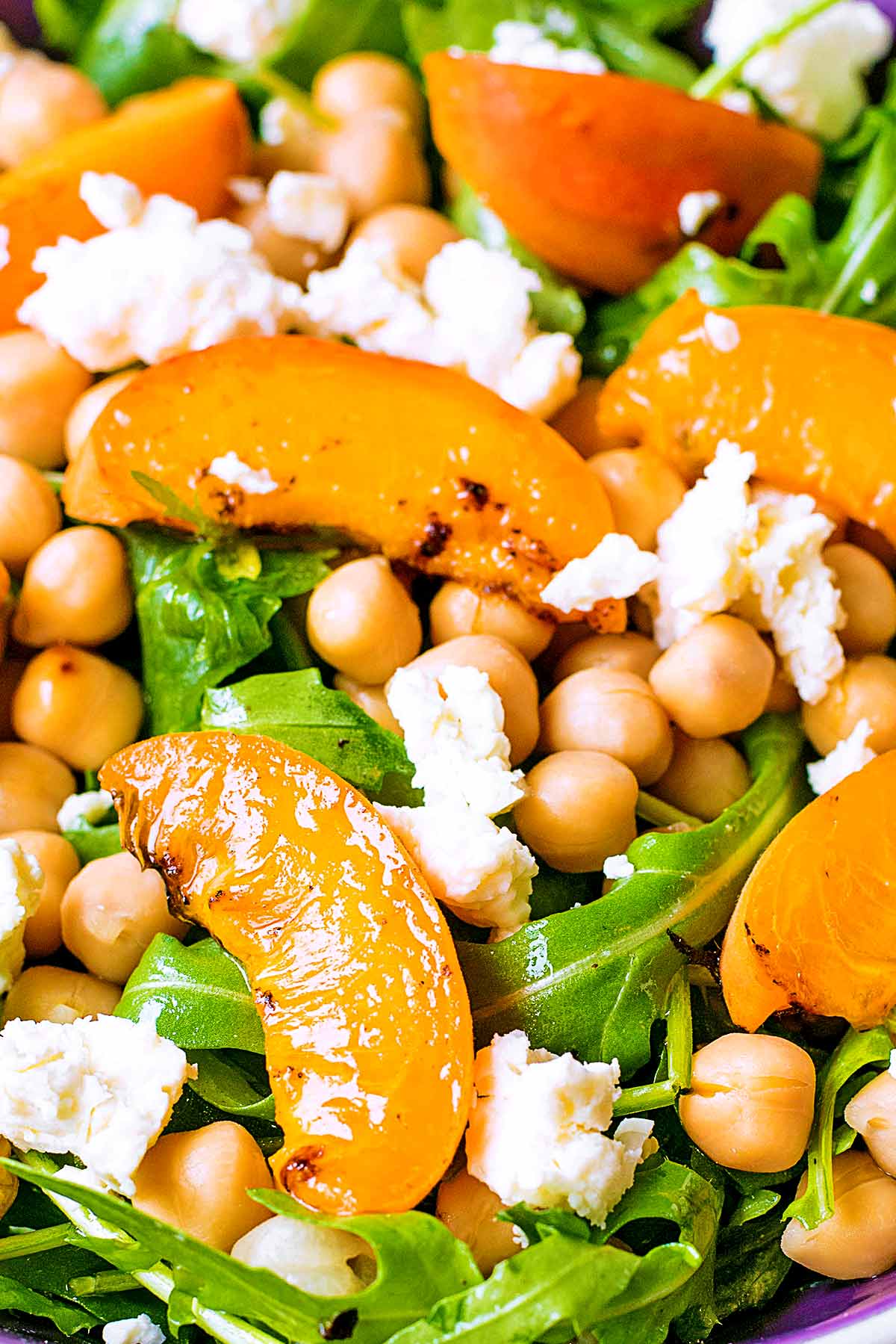 Apricot, Chickpea and Feta Salad on top of salad leaves.