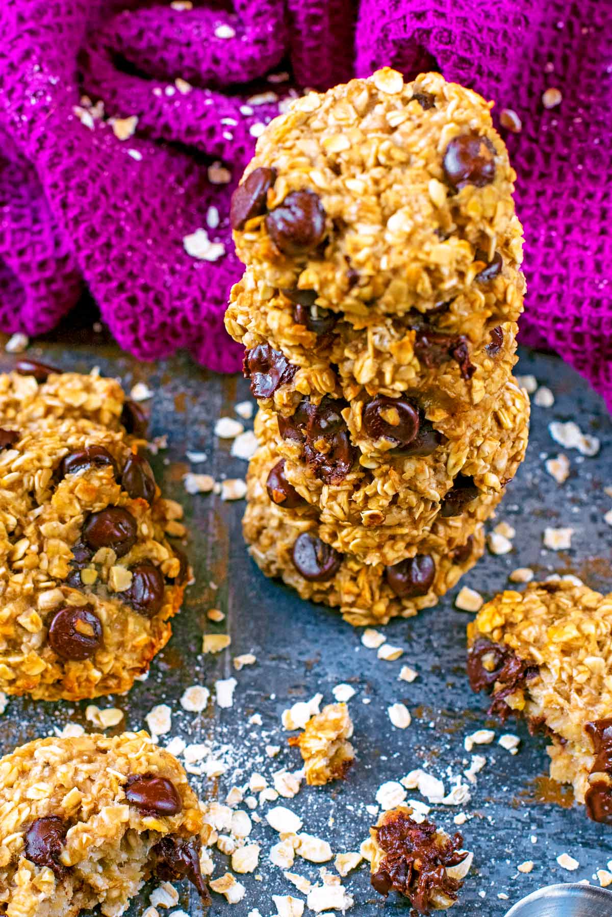 Oat cookies in a pile with oats scattered around.