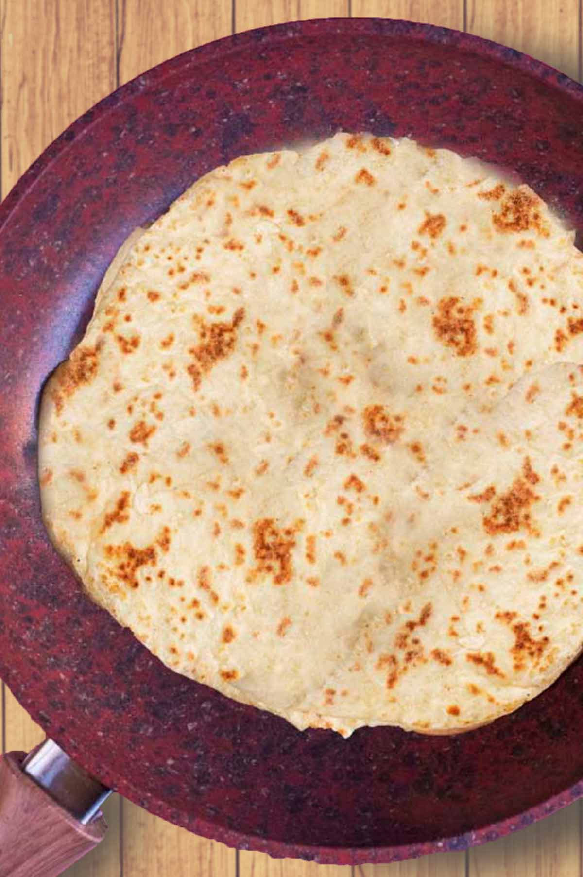 A frying pan with a cooked flatbread.