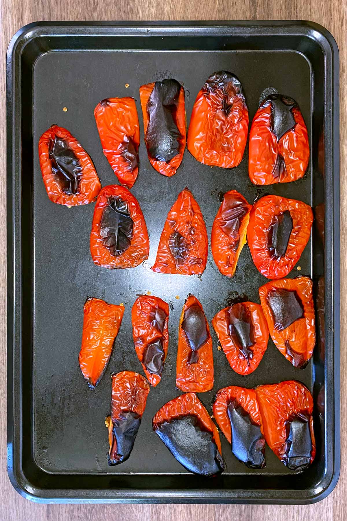 Roasted red peppers on a baking tray.