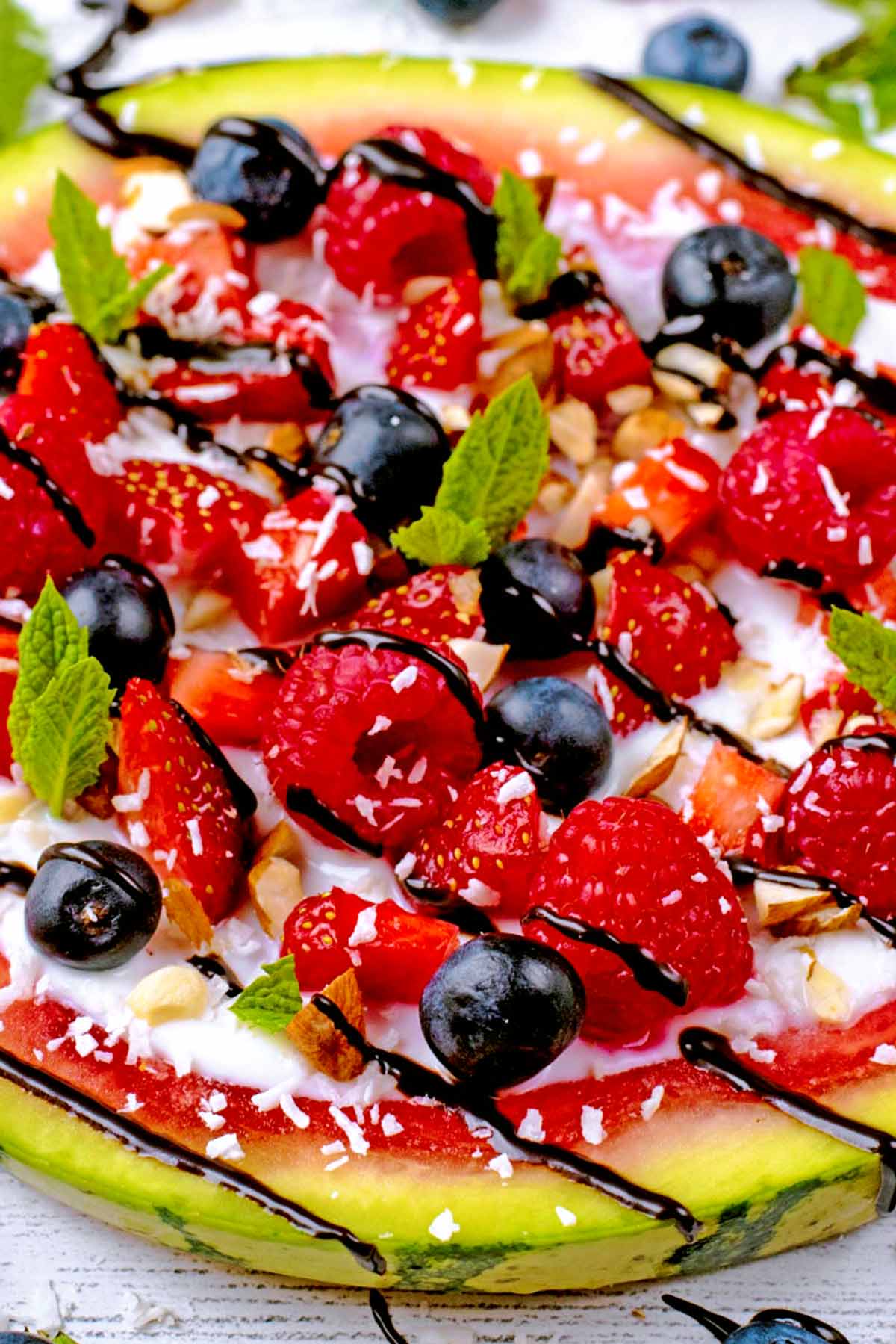 A slice of watermelon with strawberries, raspberries and blueberries.