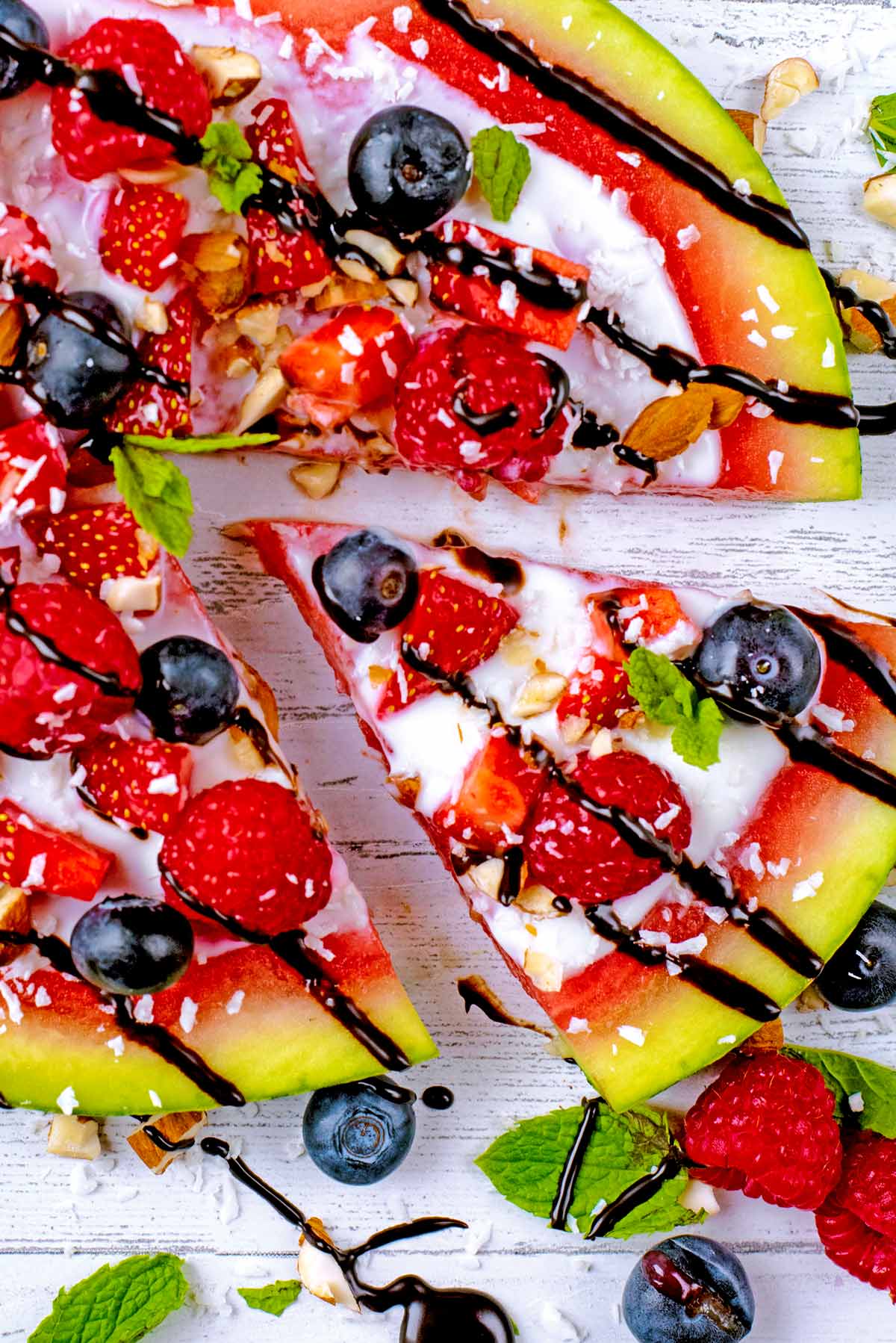 Watermelon fruit pizza with a slice cut from it.