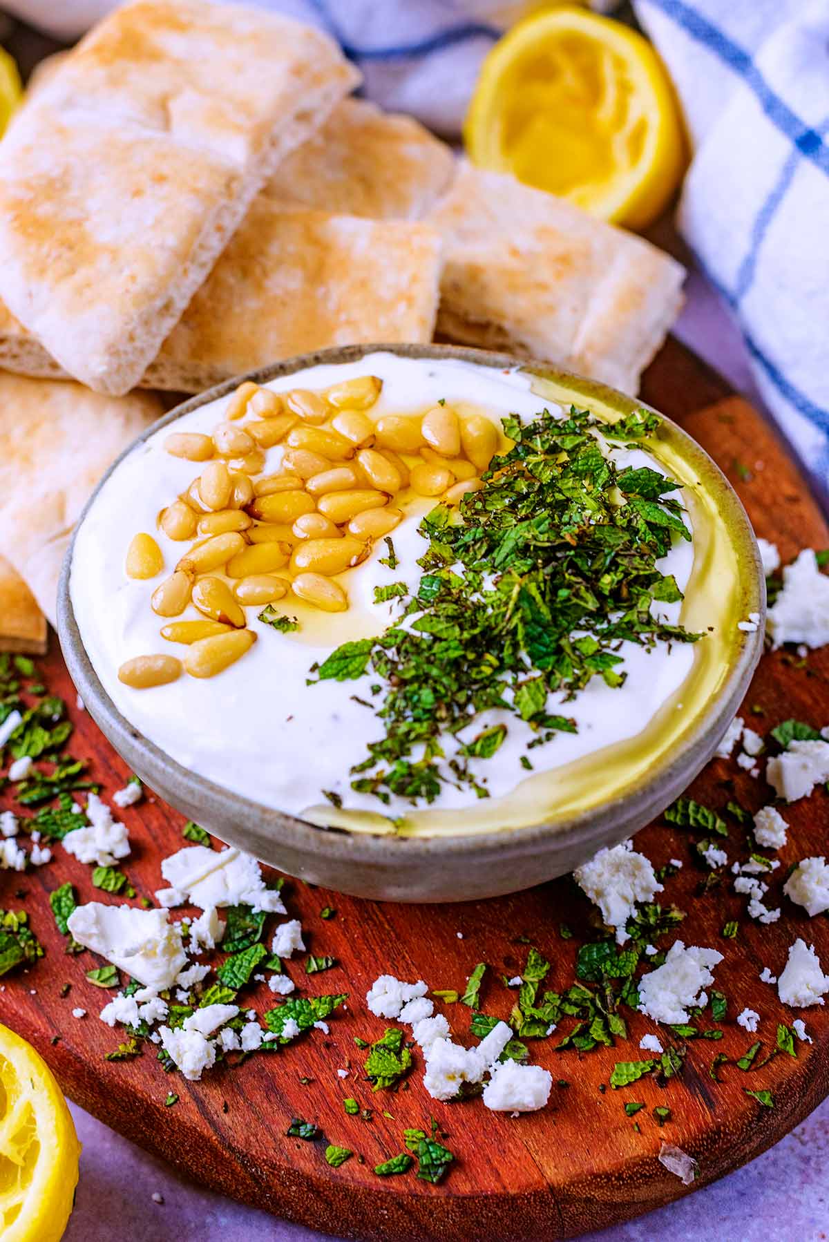A bowl of feta dip in front of some sliced pita breads.