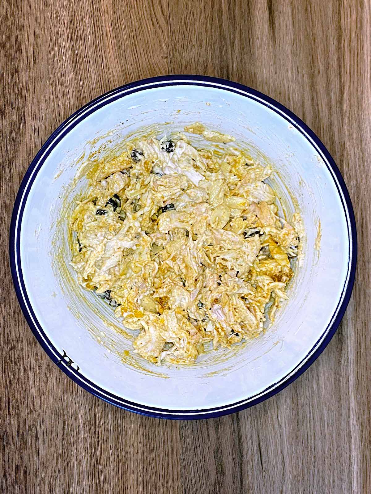 Mixed coronation chicken in a bowl.