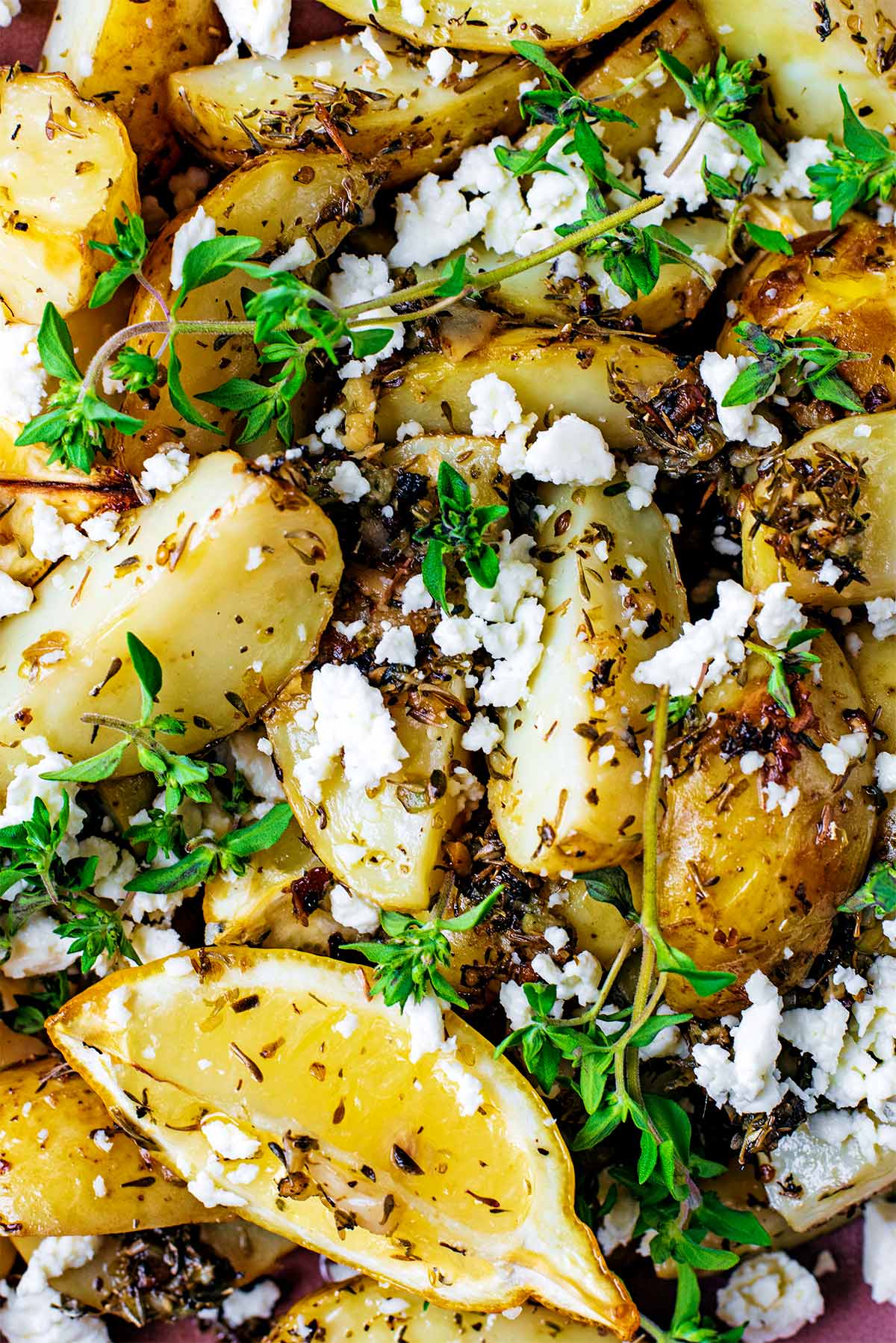 Cooked new potatoes covered in seasoning and sprinkled with feta.