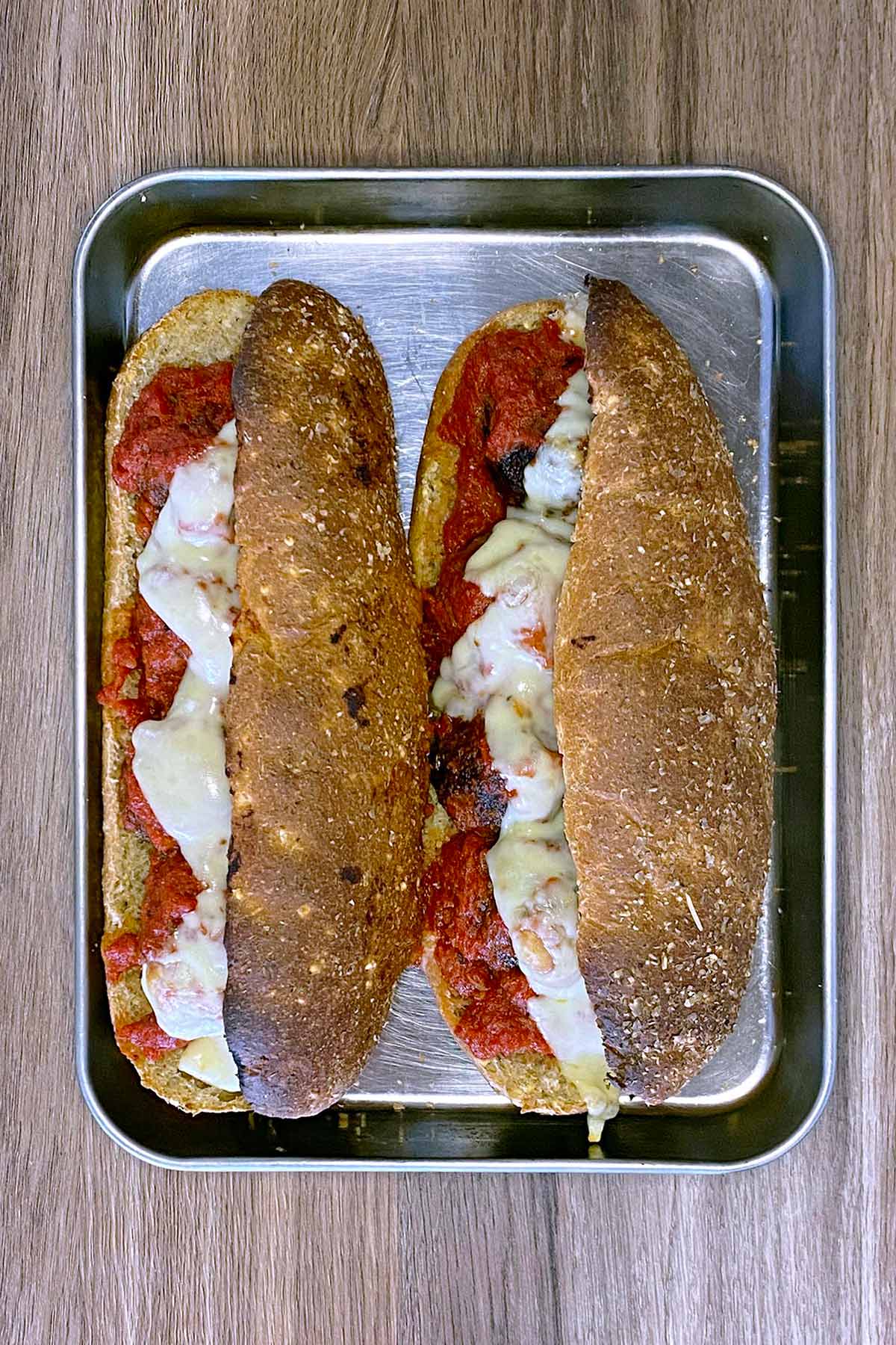 Two baked meatball subs with toasted bread and melted cheese.