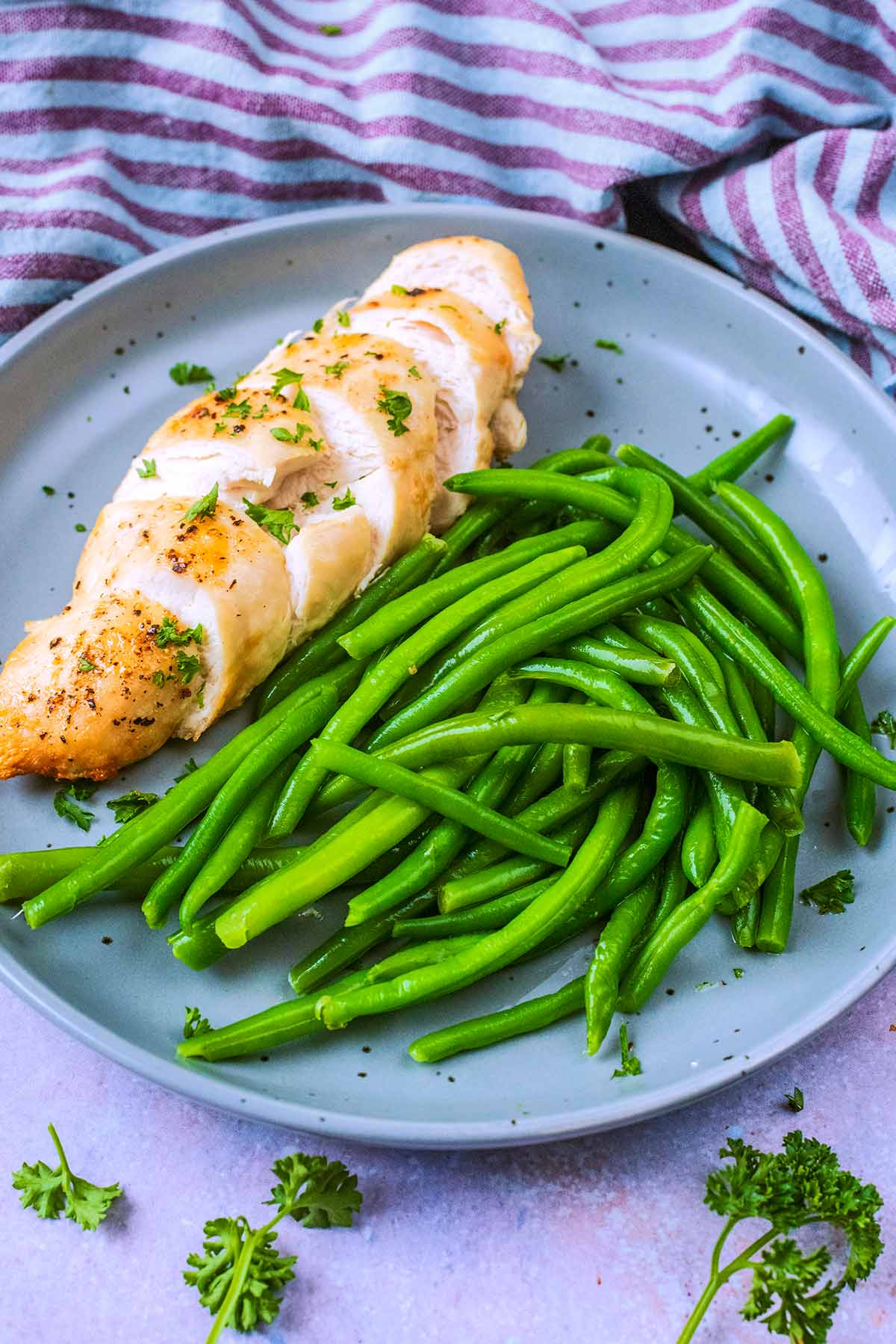 A plate of sliced chicken breast and green beans.