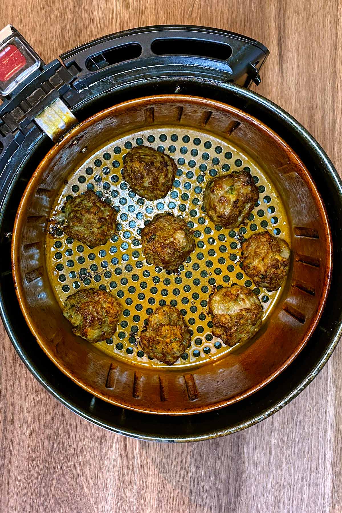 Cooked meatballs in an air fryer.
