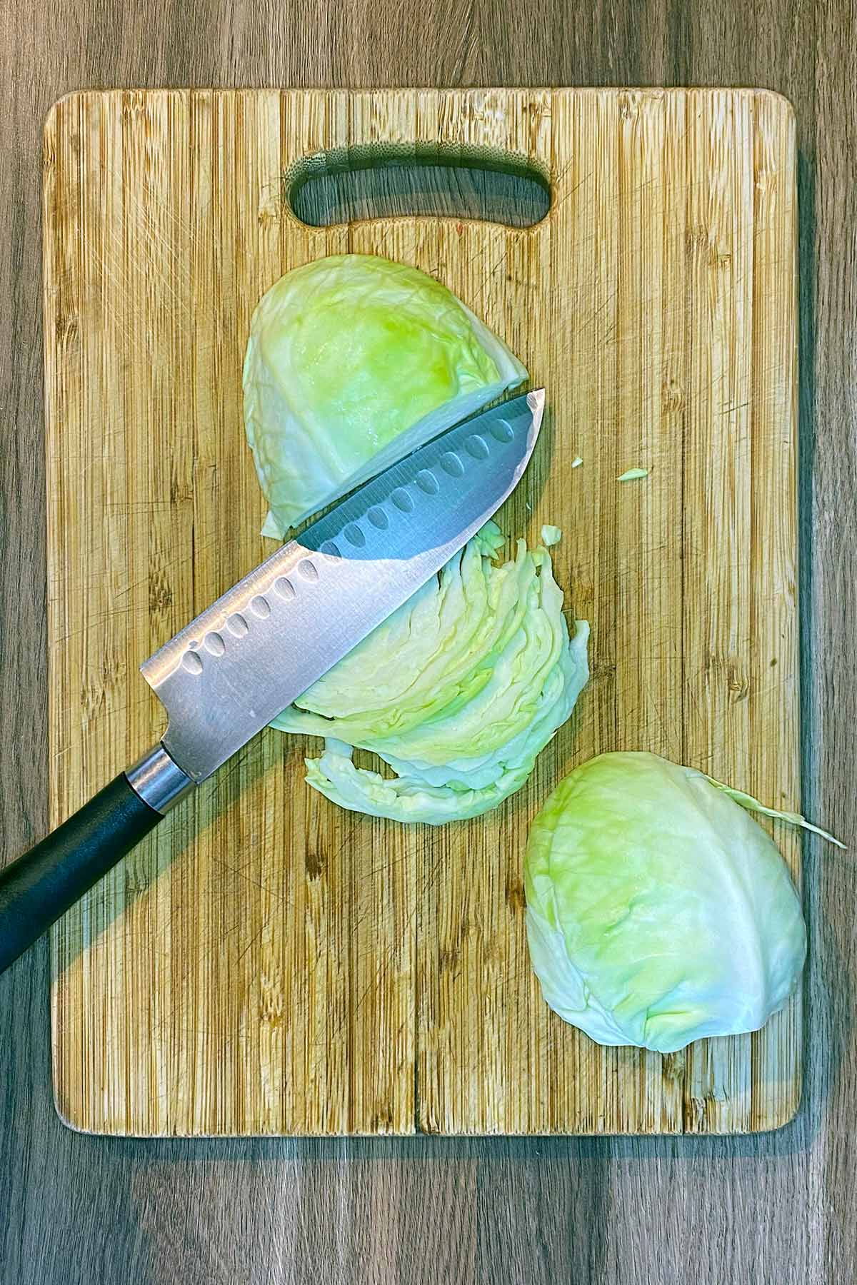 A chopping board with a chopped cabbage on it.