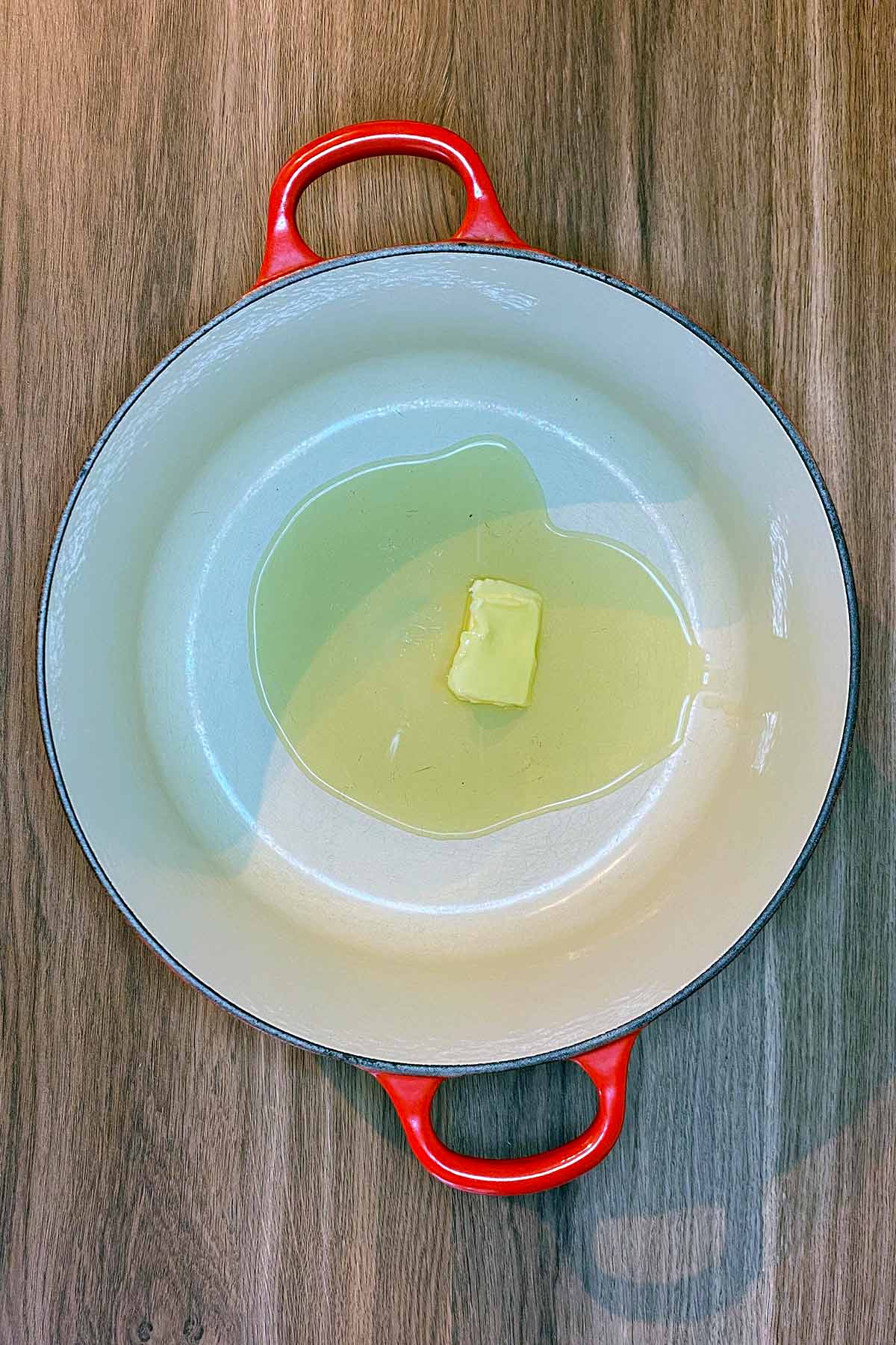 Oil and butter in a large red pan.