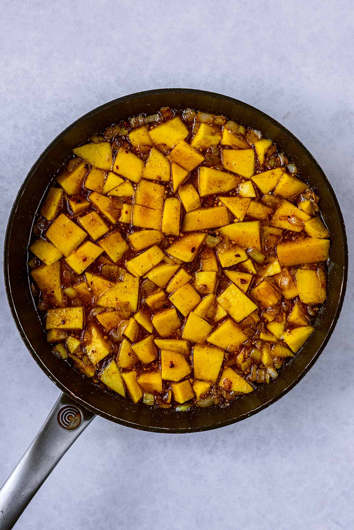 Chopped mangoes cooking in the pan.
