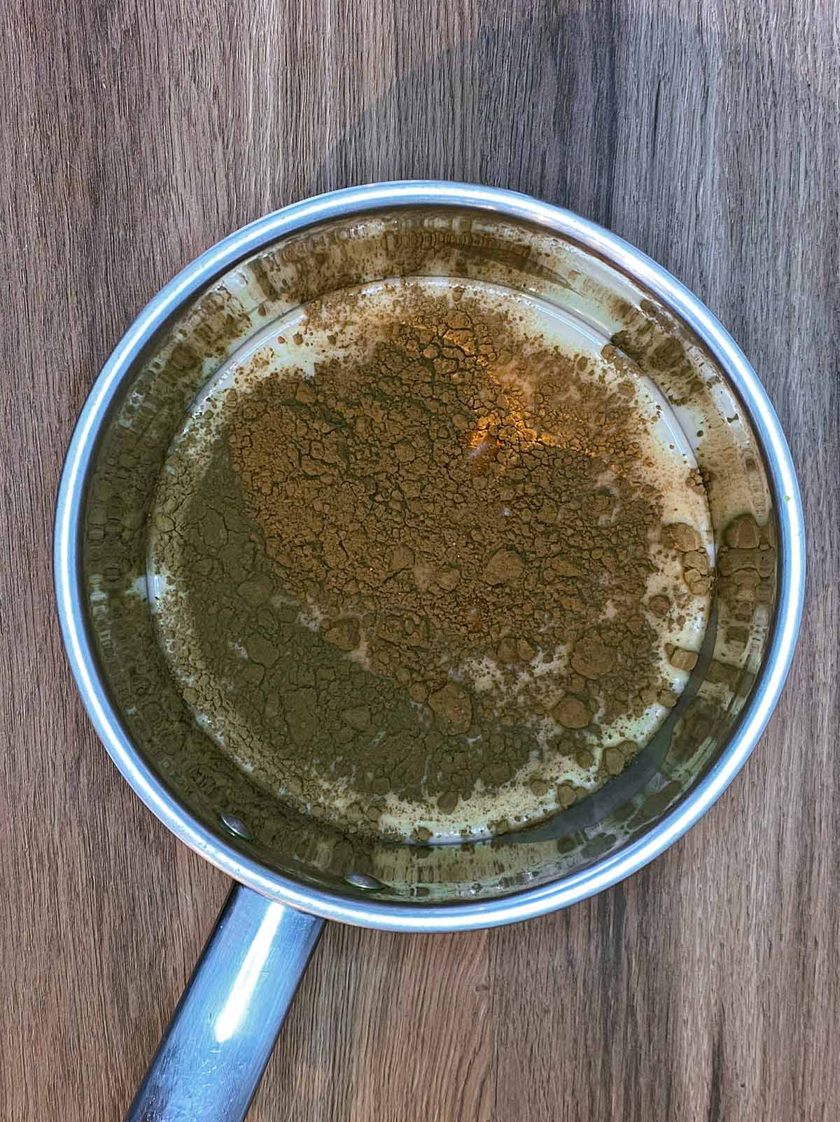 A saucepan full of oat milk and cocoa powder.