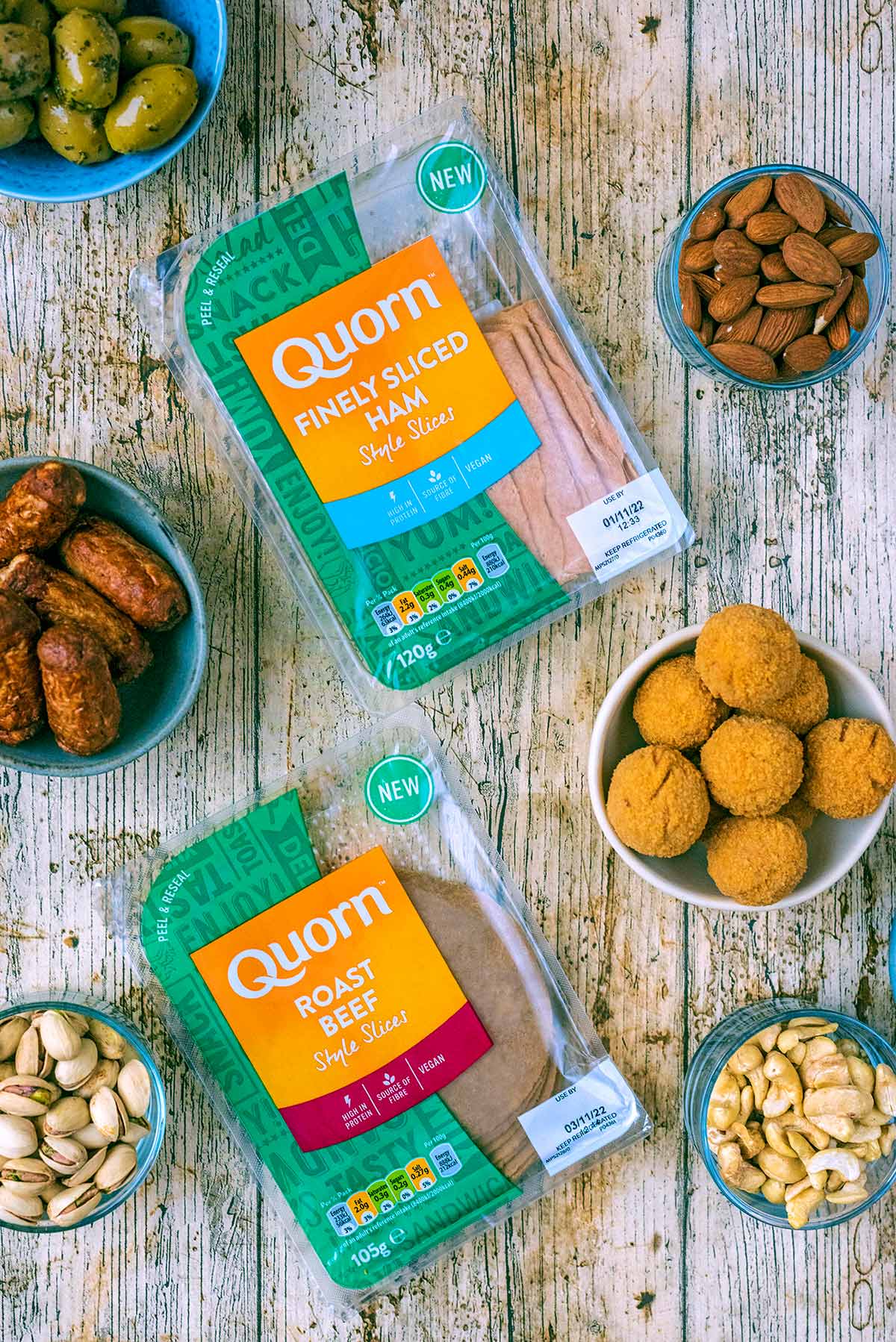 Two packs of Quorn deli slices on a wooden surface.