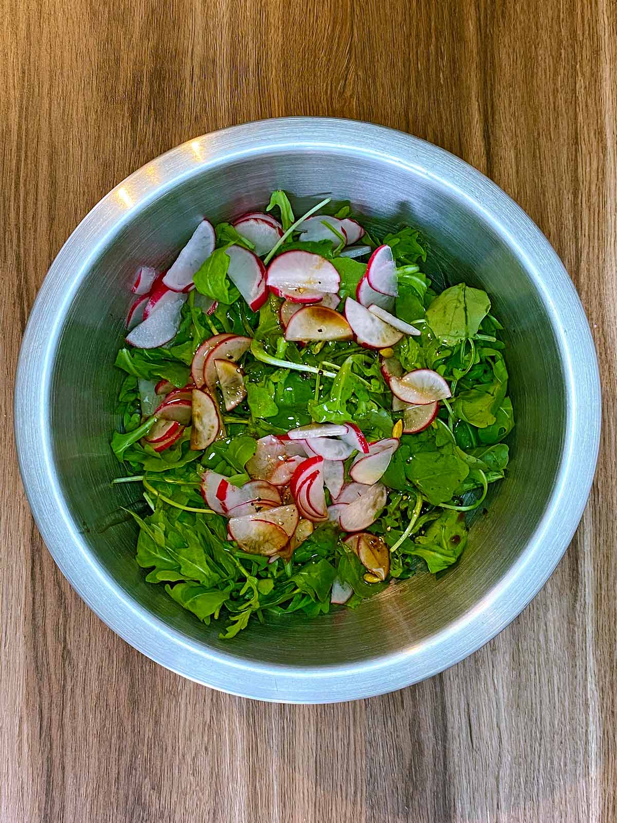 Dressing poured over the lettuce and radish.