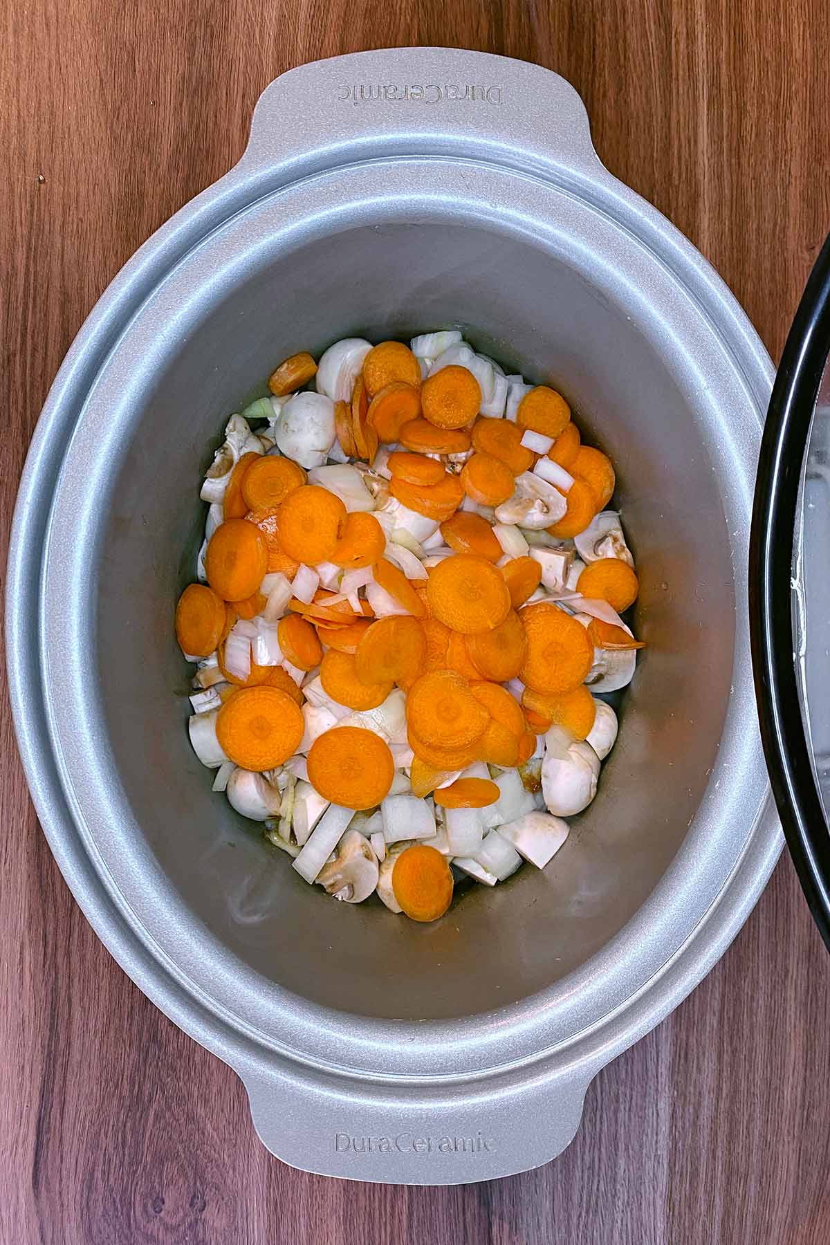 Chopped carrot, onion and mushrooms added to the slow cooker.