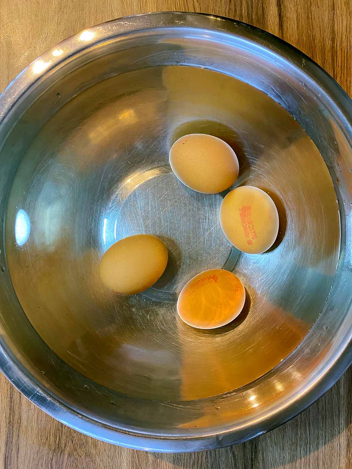 Four eggs in a bowl of water.