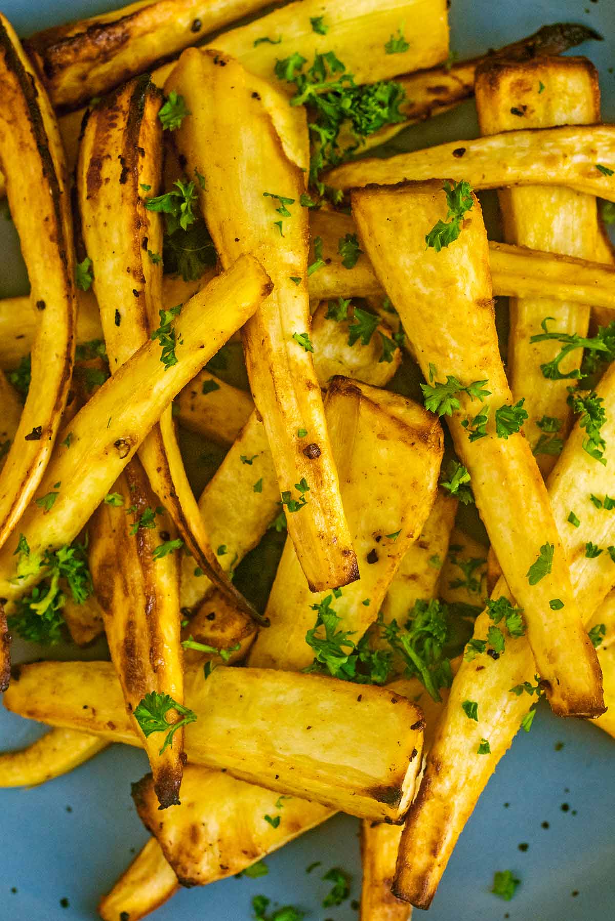 Cooked parsnips with chopped parsley sprinkled over them.