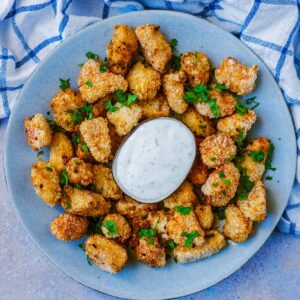 Air Fryer Popcorn Chicken on a plate with some dip.