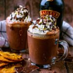 Two glasses of Baileys Hot Chocolate topped with cream.