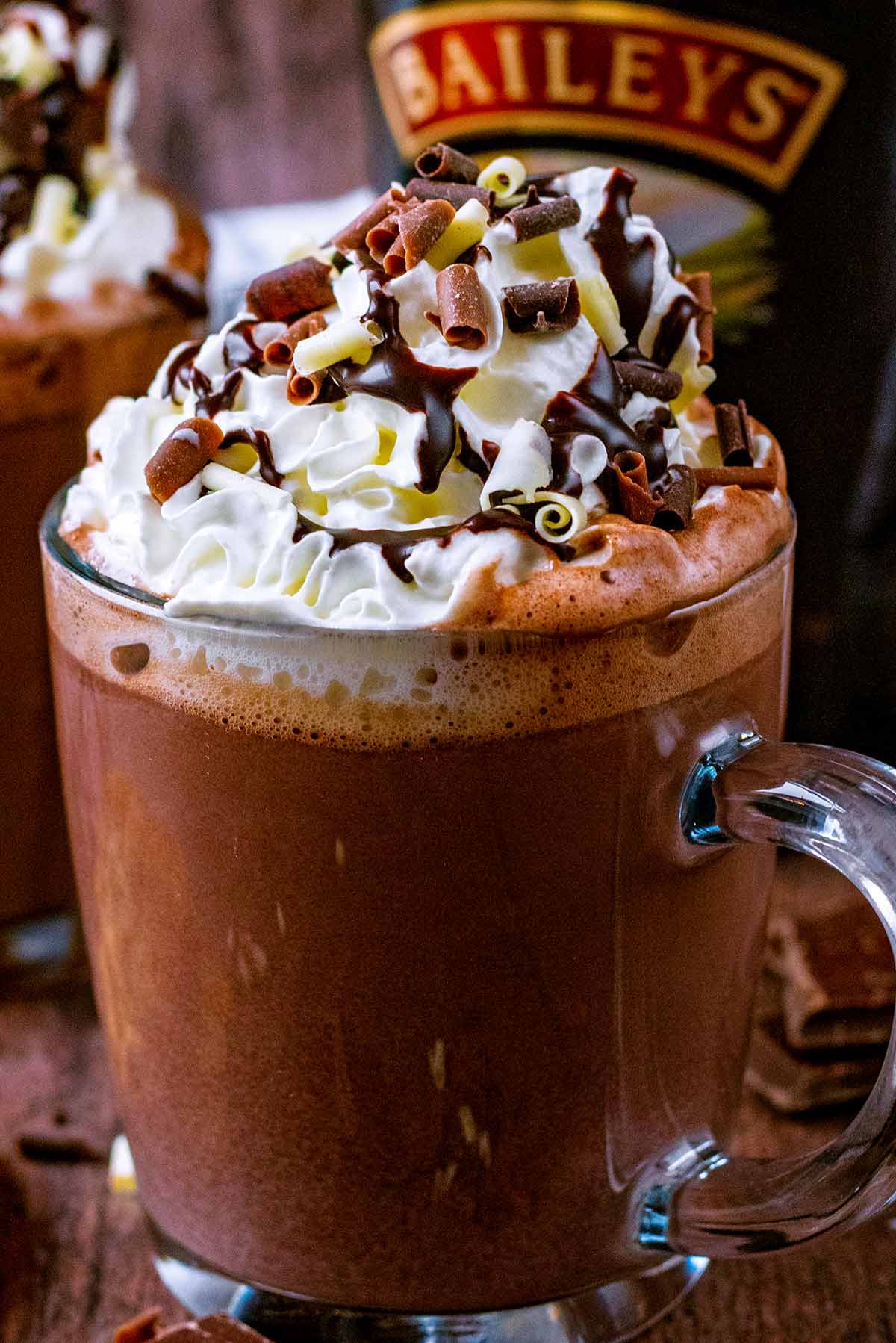 Hot chocolate topped with whipped cream, chocolate sauce and chocolate curls.